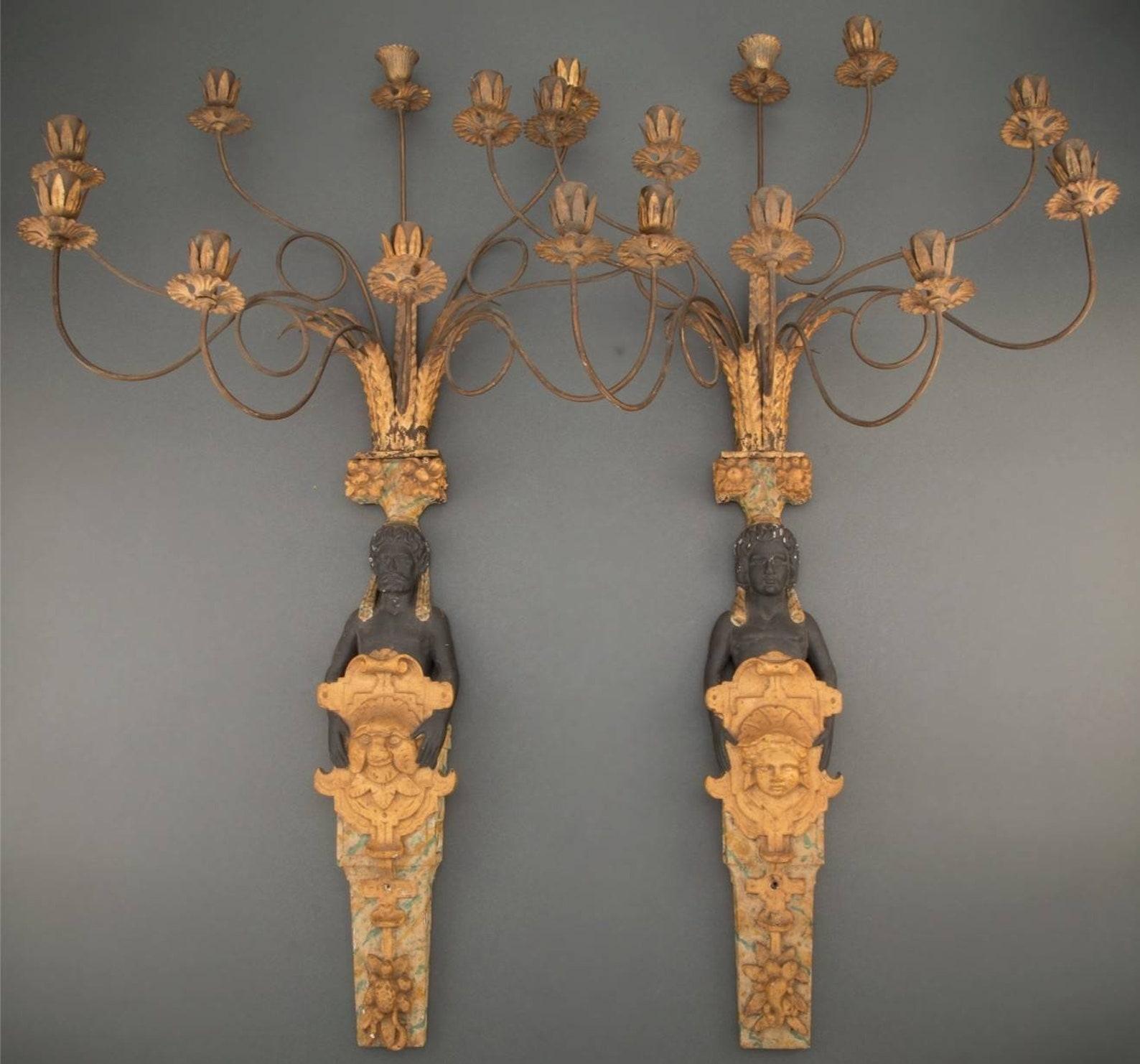 A most impressive pair of French Napoleon III Second Empire Period Egyptian Revival style gessoed, gilded and polychrome painted wood and gilt metal foliate scroll arm nine light
candle sconces. 

Hand-crafted in France, most likely Parisian