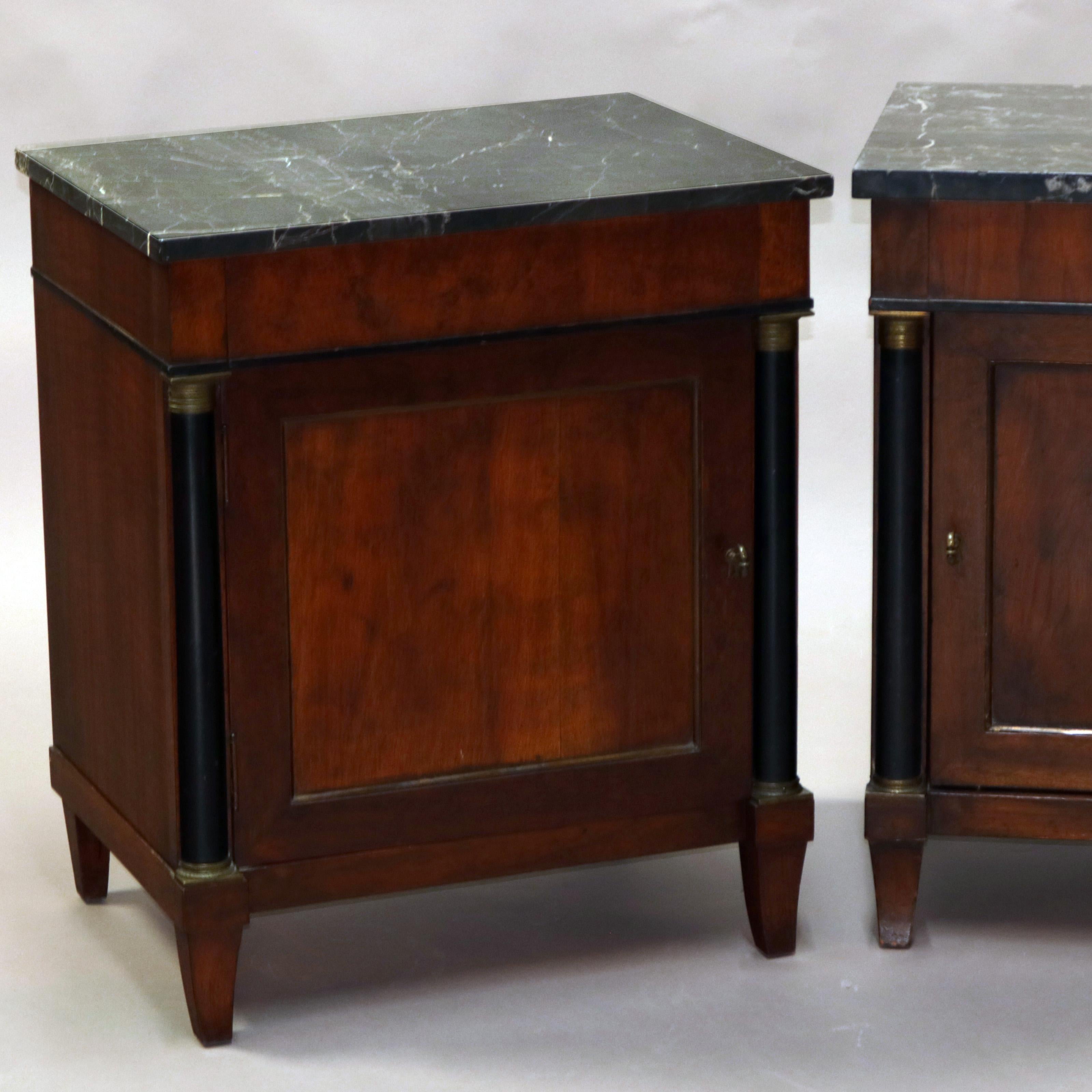 An antique pair of French Empire side table offer mahogany construction each with a marble top surmounting single door cabinet flanked by ebonized turned columns with bronze mounts, raised on square tapered legs, circa 1890

Measures- 26.75