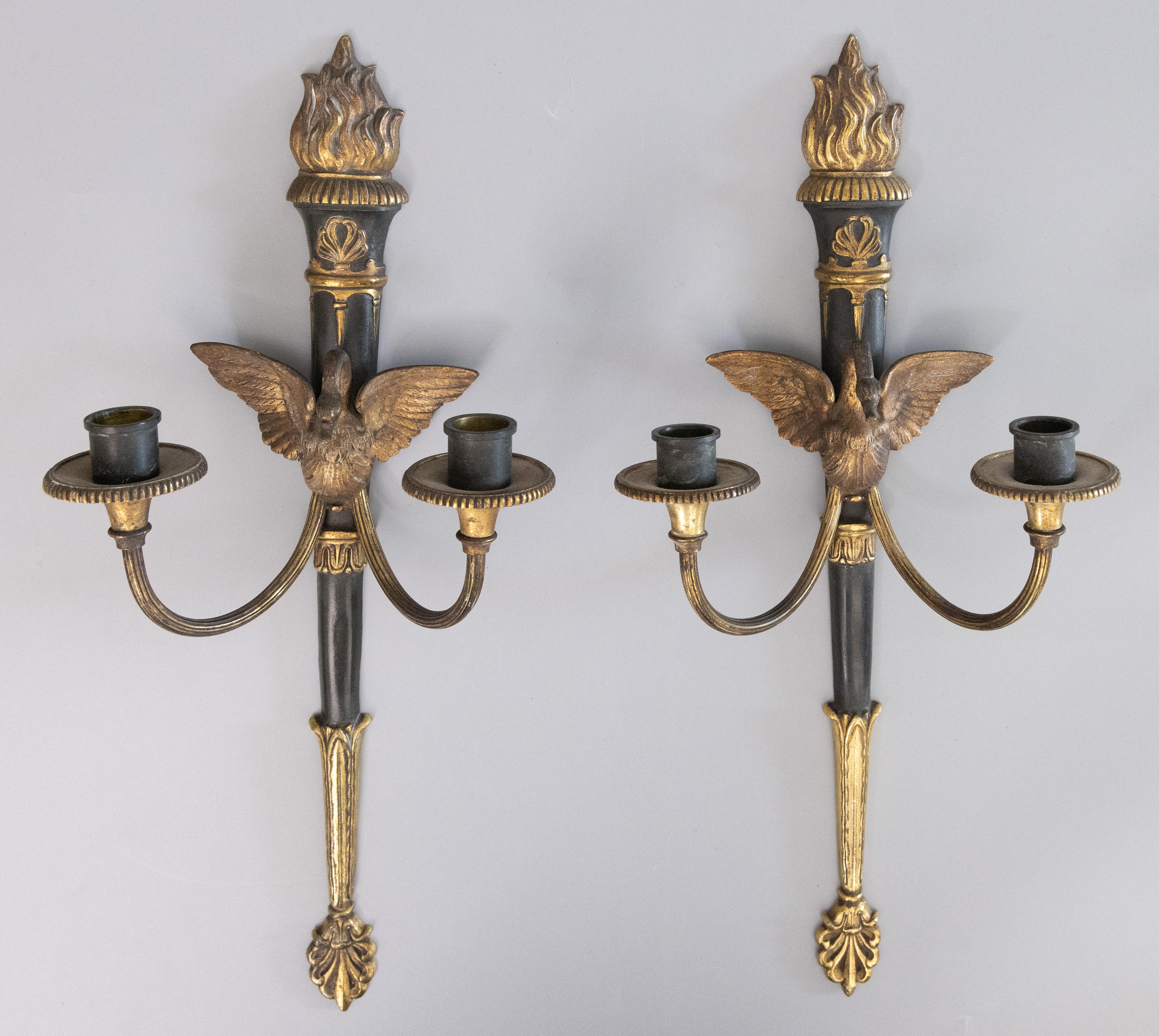 A gorgeous pair of French Empire Style gilded bronze candle sconces, circa 1900. These beautiful sconces are ebonized with gilt swans, torches, and ormolu decorations in a lovely gilt patina.

Dimensions
7.5