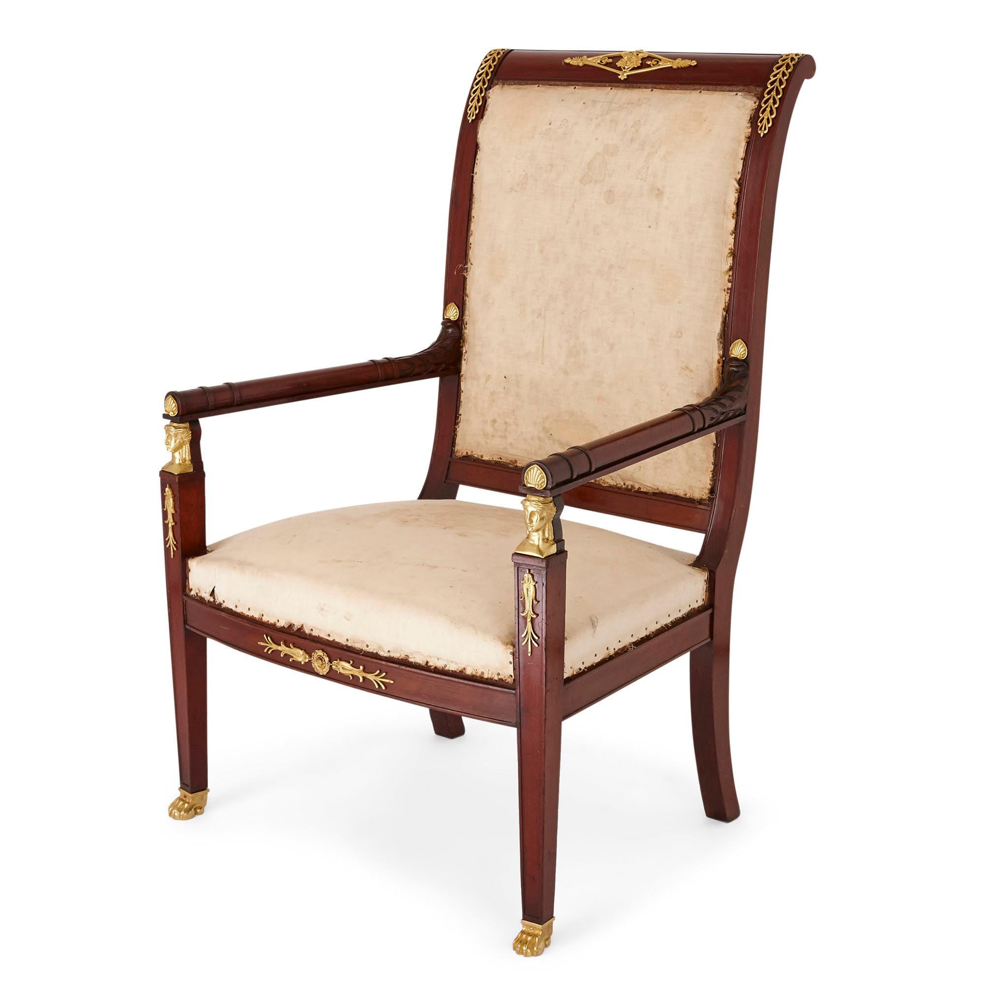 Pair of antique French Empire style mahogany and gilt bronze armchairs.
French, 19th century
Dimensions: Height 108cm, width 70cm, depth 60cm

This pair of French Empire style fauteuil armchairs are crafted from mahogany with ormolu mounts and