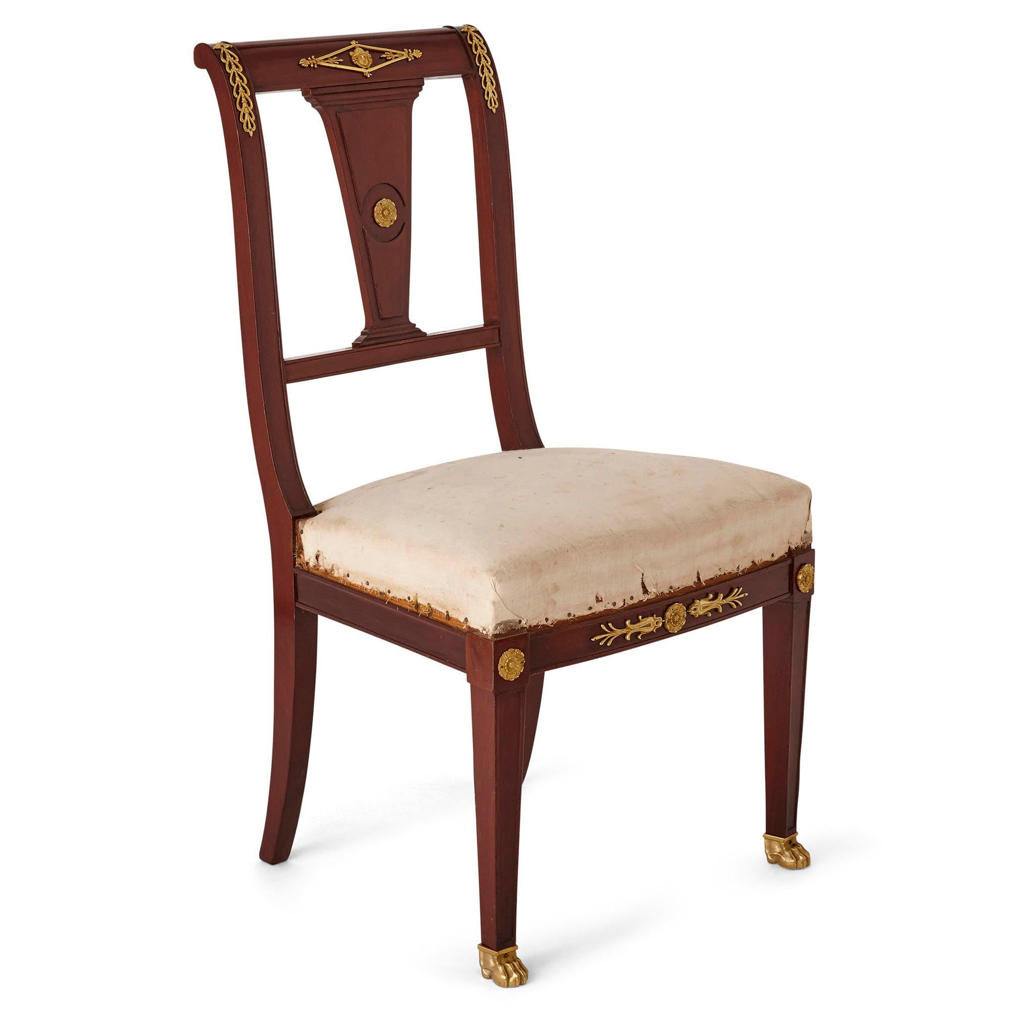 Pair of antique French Empire style mahogany and gilt bronze chairs
French, 19th century
Dimensions: Height 93cm, width 51cm depth 48cm

This pair of French Empire style side chairs are crafted from mahogany with ormolu mounts and cream