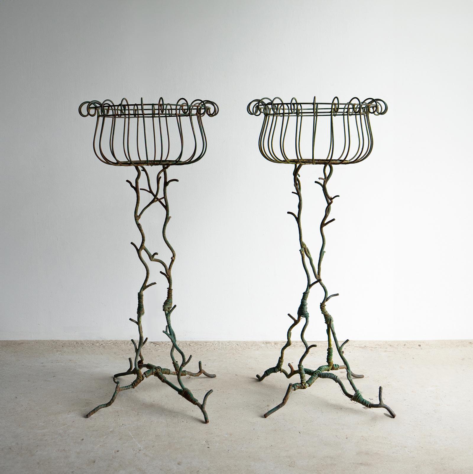 PAR DE MACETEROS ANTIGUOS

Bases naturalistas de hierro forjado y alambrismo del gusto del faux bois para emular ramas y ramitas.

Cestas decorativas de alambre en las secciones superiores para sujetar macetas.

Pintura verde naturalmente desgastada