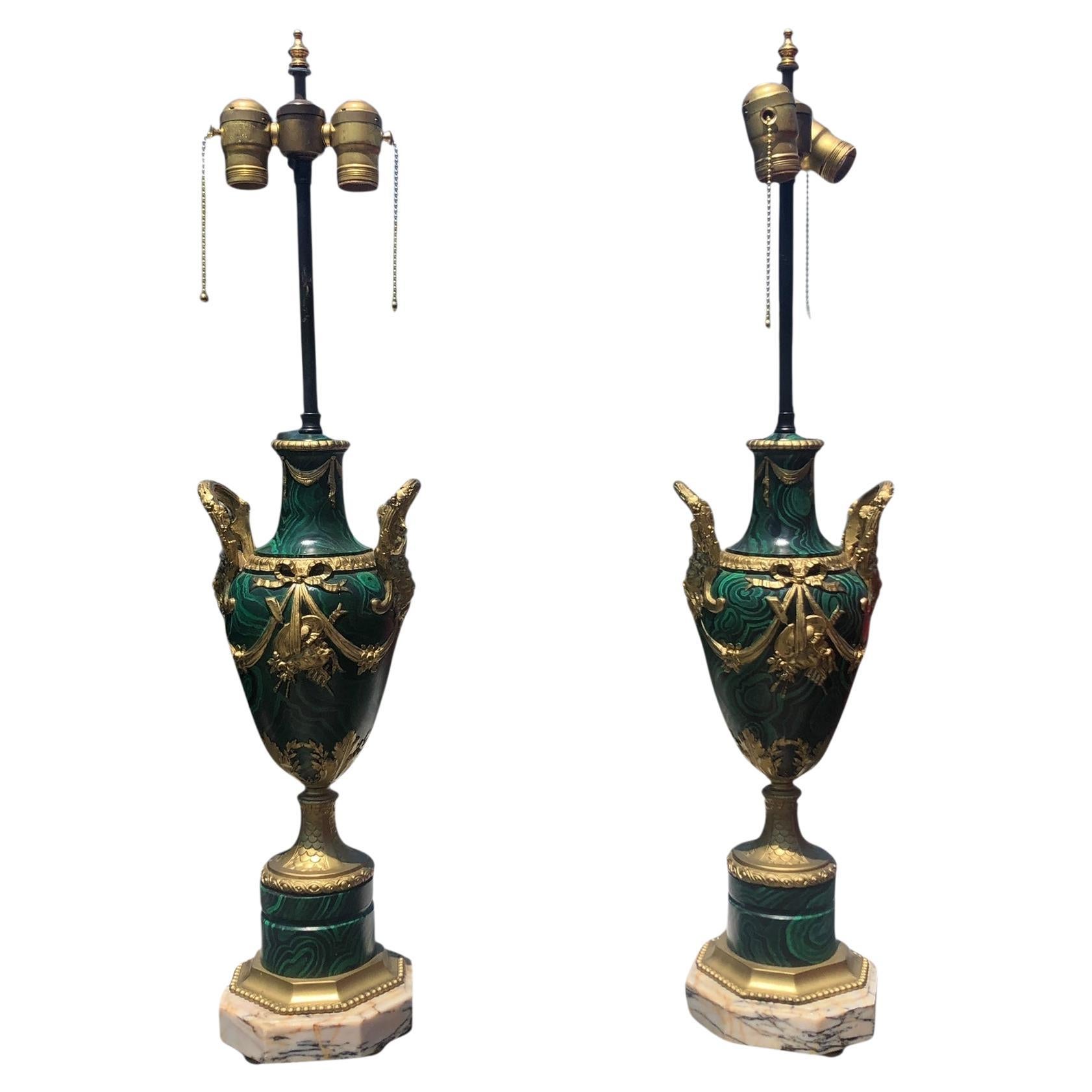 Coppia di lampade francesi antiche in finta malachite. Lampade eccezionalmente ben realizzate con un eccellente realismo delle urne in metallo dipinto per sembrare pietra malachite. Motivi classici, come le volute e il volto di un satiro, adornano