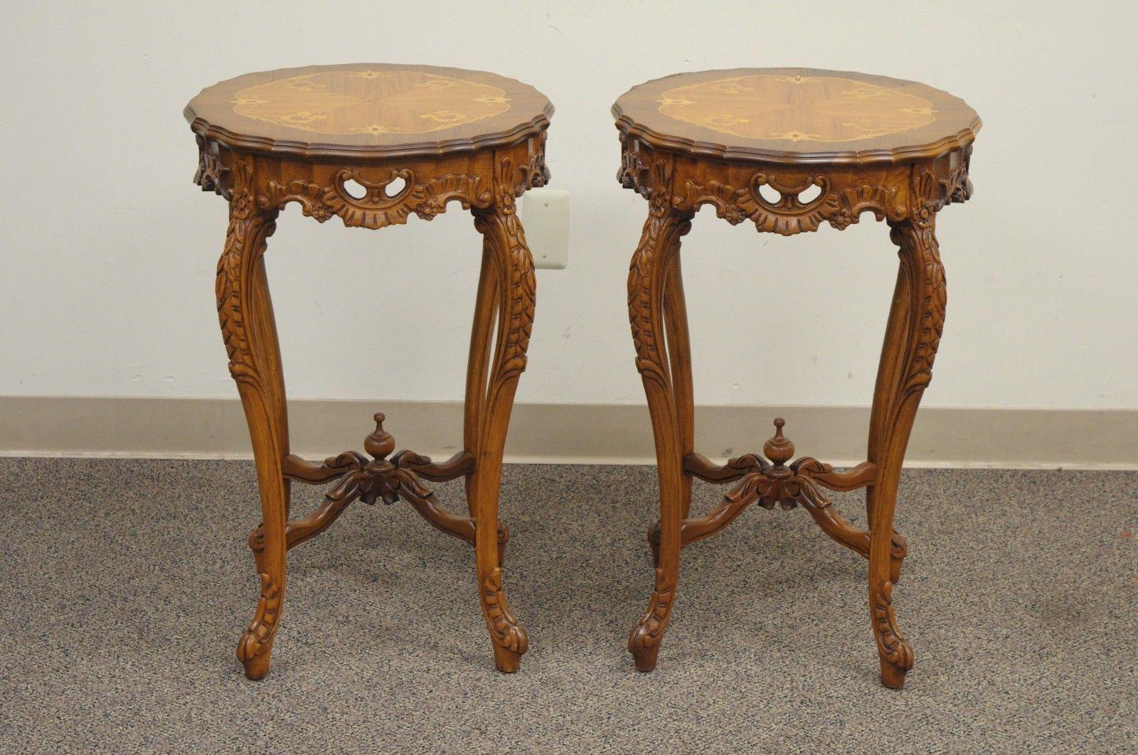Pair of Antique French Louis XV style floral satinwood inlaid round end tables. Item features carved walnut bases, pierce carved skirts, satinwood inlaid floral tops, cabriole legs, stretcher bases with finials, and beautiful French form, early to