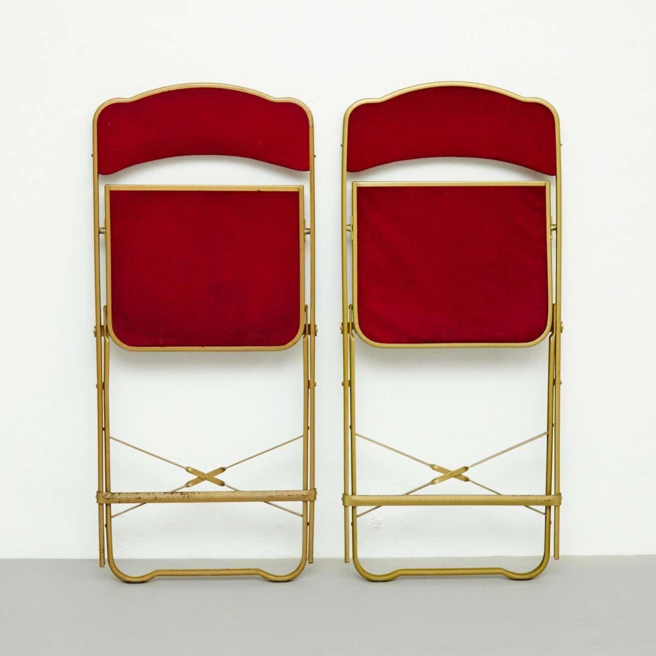 Pair of antique folding theater chairs.
By unknown manufacturer, France, circa 1960.
In original condition, with minor wear consistent with age and use, preserving a beautiful patina.

Material:
Metal

Dimensions:
D 44.5 cm x W 43 cm x H