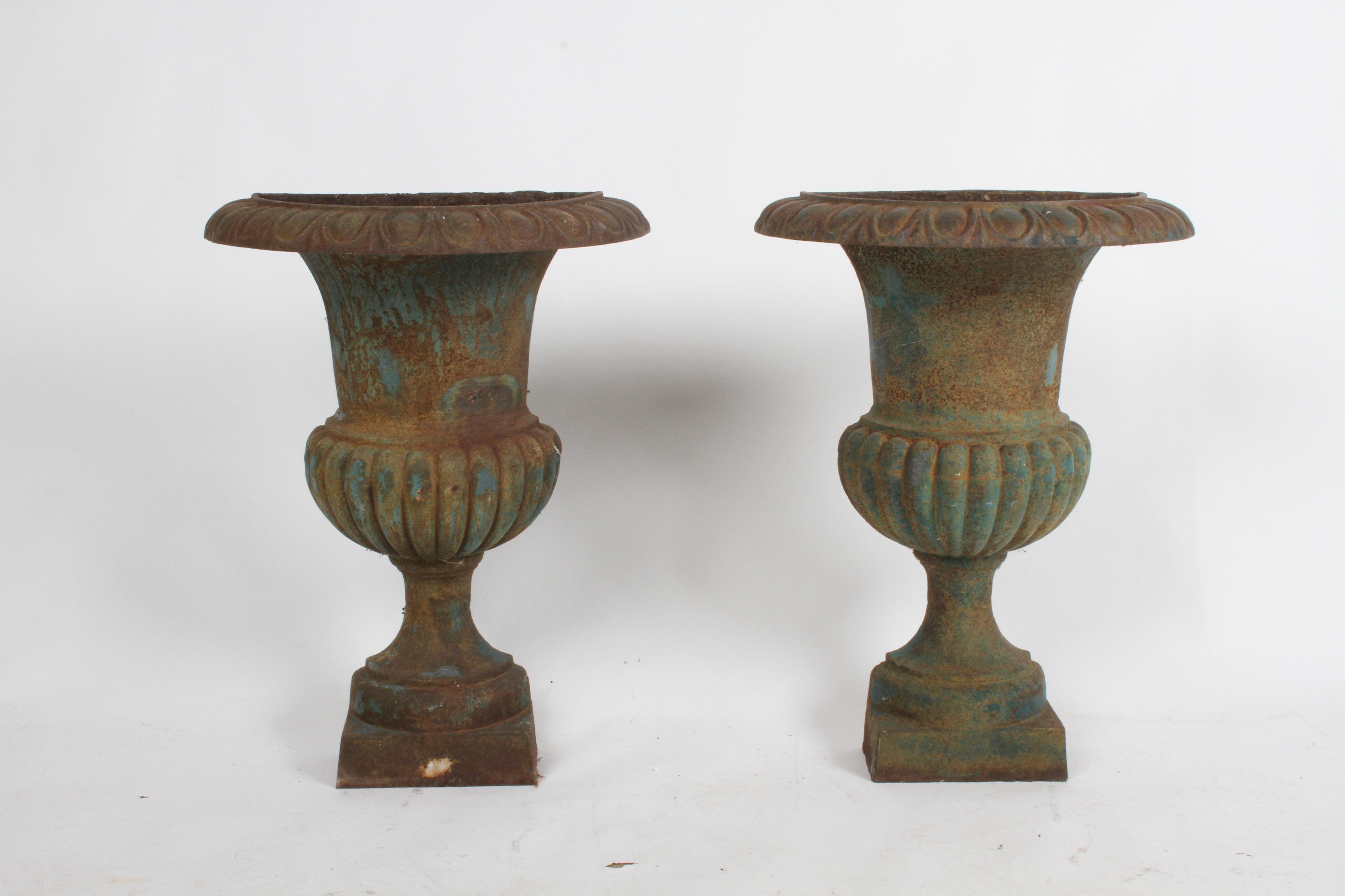Pair of unusual early 20th century antique French cast iron half round demilune wall mounted urn form wall planters. Having traces of blue paint, egg and dart pattern with classical quarter-lobed body on plinth base. Overall rust, very heavy no