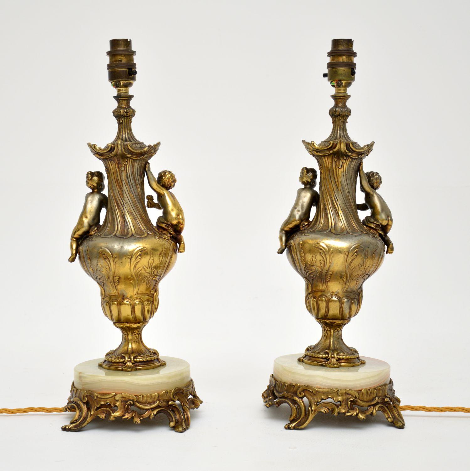 A stunning pair of antique French table lamps in gilt metal and onyx. These were made in France, they date from around the 1920’s period.

They are of lovely quality and depict cherubs around an urn shaped central column. The gilt metal work has