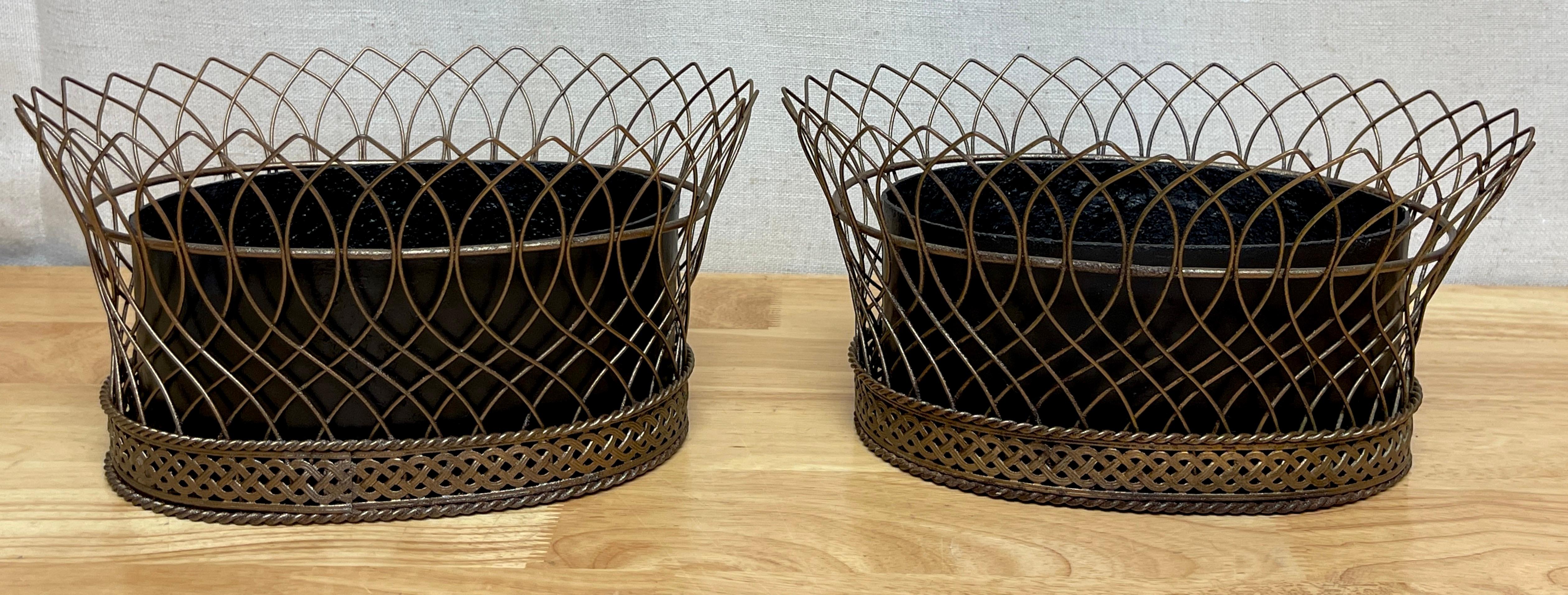 Pair of antique French gilt tôle & iron tole metal filigree oval planters 
France, circa 1900s
Each one of oval basket form, the flaring woven filigree gilt tôle metal frames, retains the original removable forged cast iron liners. 

Overall