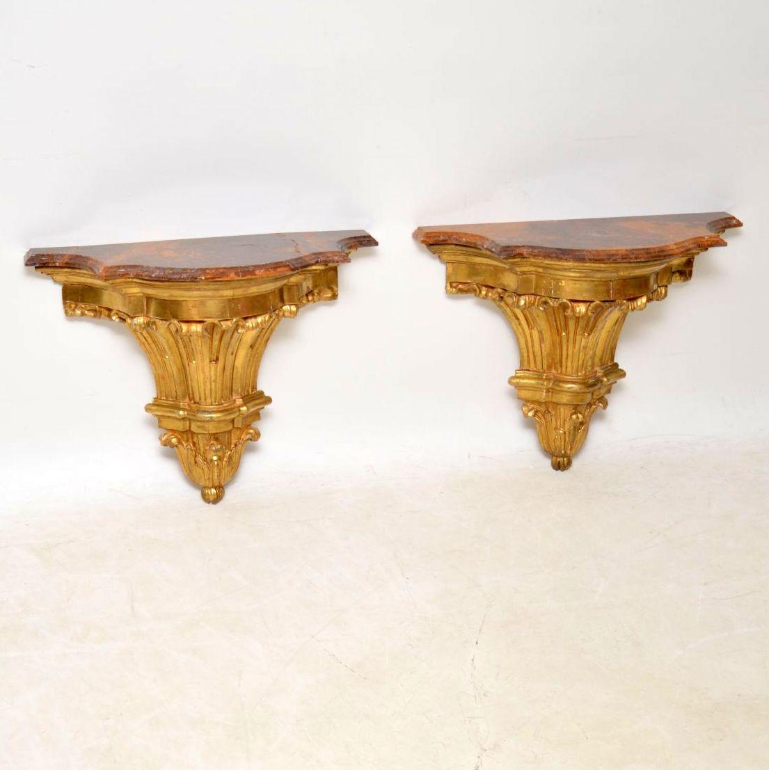 Pair of French antique giltwood wall mounting side tables with marble tops. I would date them to circa 1850s period and would say the marble tops are more recent. The gilt work is all original and there is a bit of natural ageing in places, so