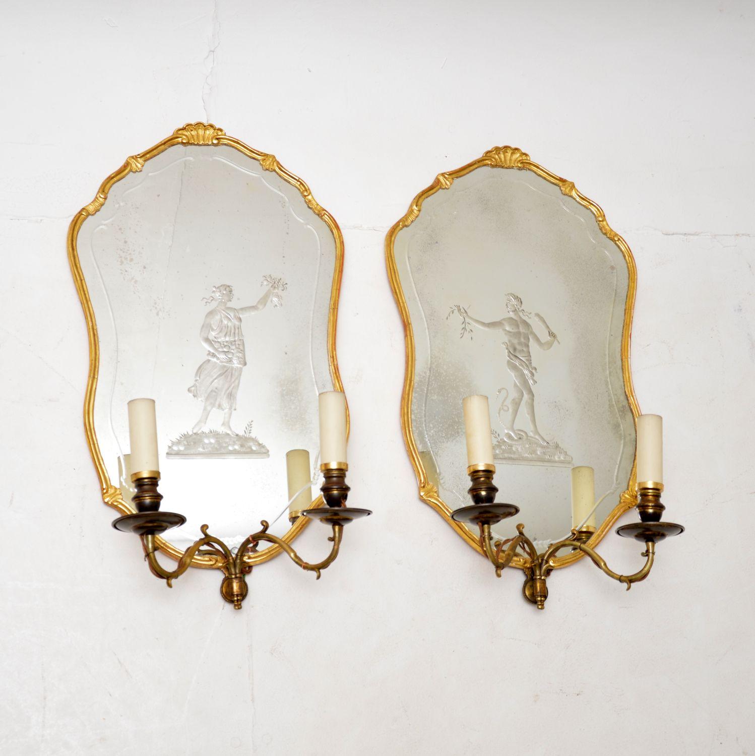 An exquisite pair of antique gilt wood mirrors with wall sconce lamps built in. We believe these are French, dating from around the 1880-1900 period.

The quality is outstanding, the gilt wood frames have a beautiful, delicate design and the