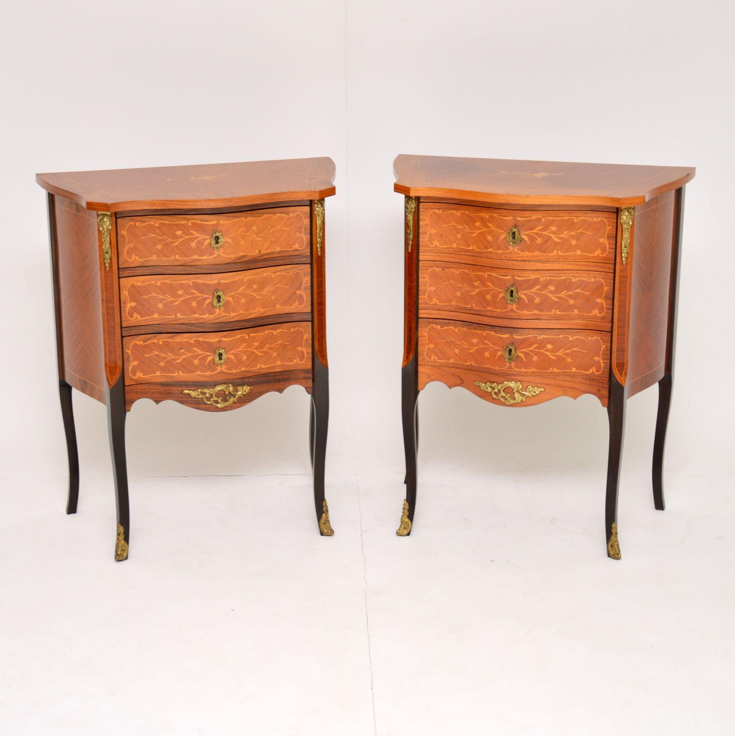 Pair of antique French style bedside chests or side tables dating from circa 1930s-1950s period and in good original condition. They are Kingwood and rosewood with floral inlays on the tops and abundant satinwood inlays on the drawers and elsewhere.