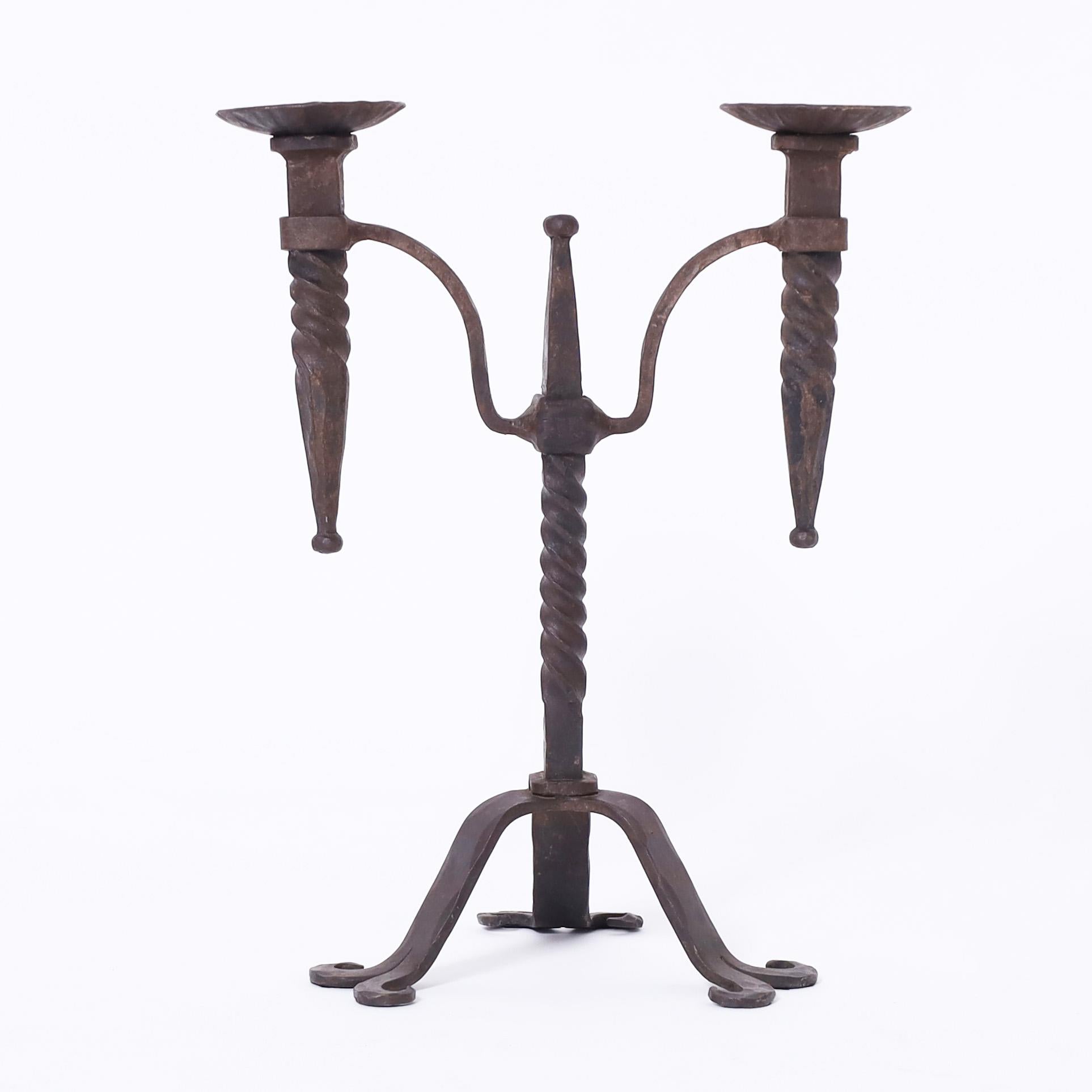 Herausragendes Paar französischer schmiedeeiserner Kerzenständer aus dem 19. Jahrhundert mit jeweils zwei Kerzenhaltern, die an einem verdrehten Mittelpfosten auf drei Cabriole-Beinen befestigt sind.