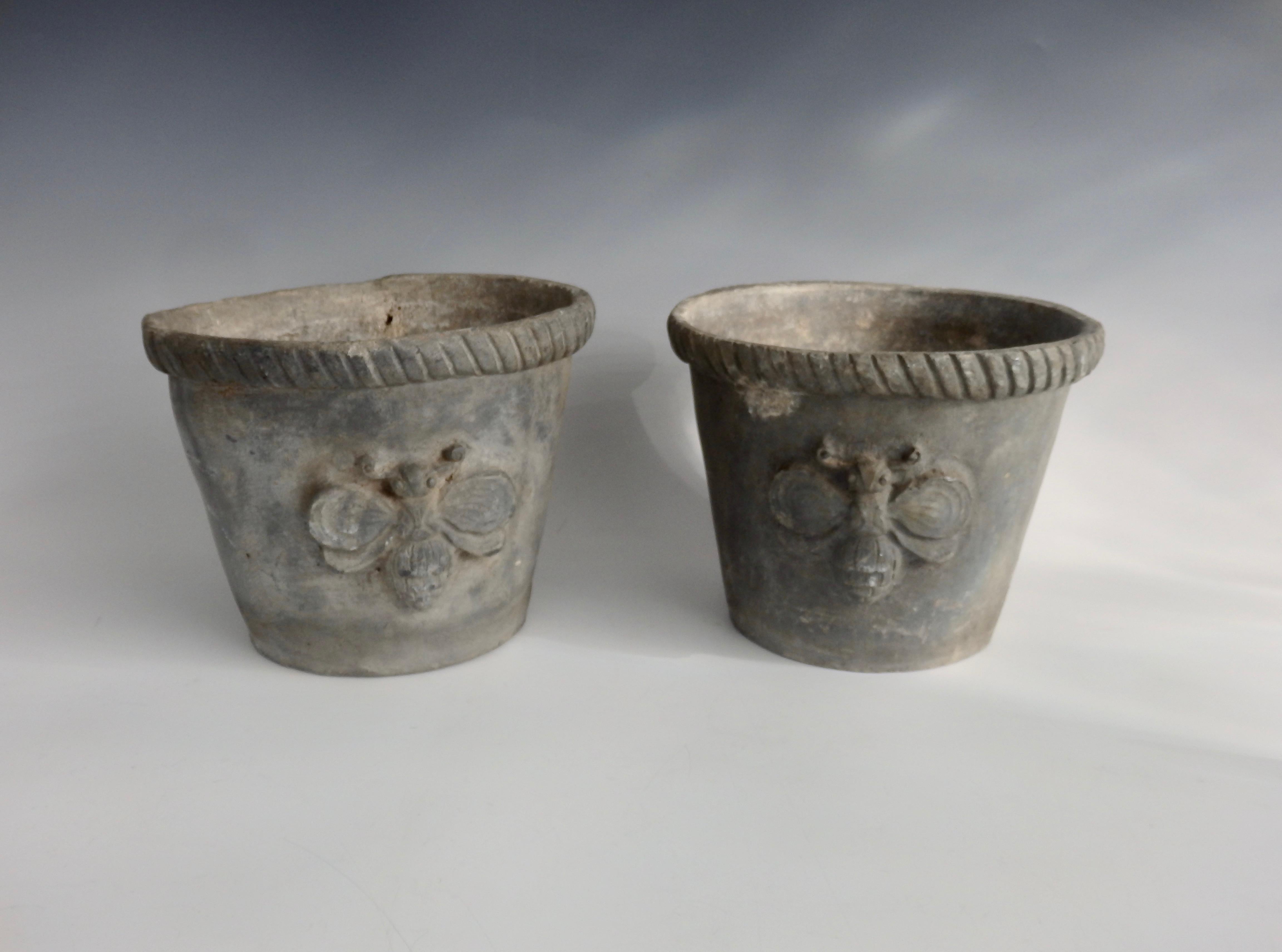 Pair of antique French garden pots in lead. Bumblebee design cast into each planter pot. Smaller third pot included.
