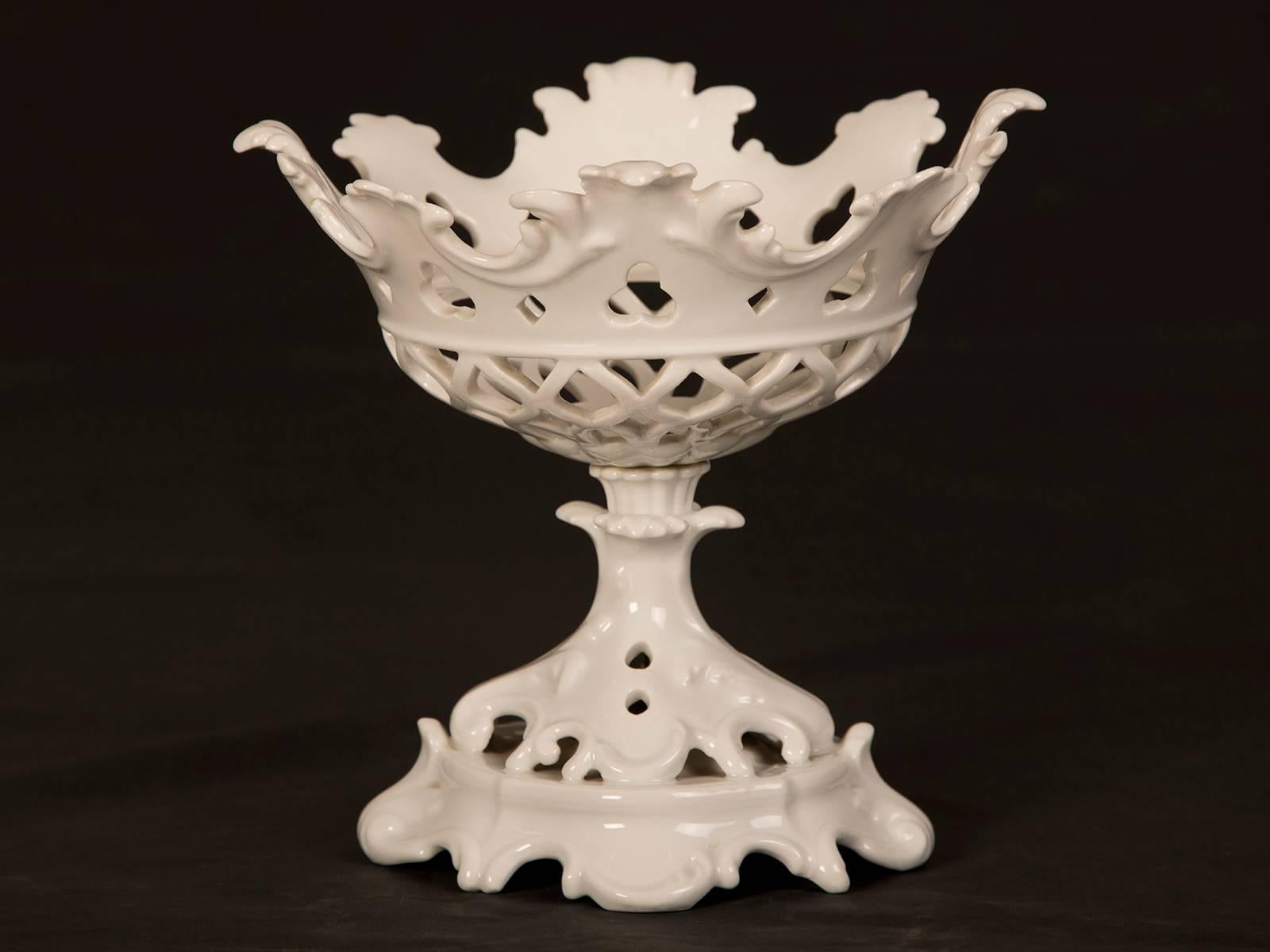 A pair of antique French Louis Philippe period white glazed porcelain table centrepieces each having an open lattice work design and mounted on a footed base from France, circa 1840.