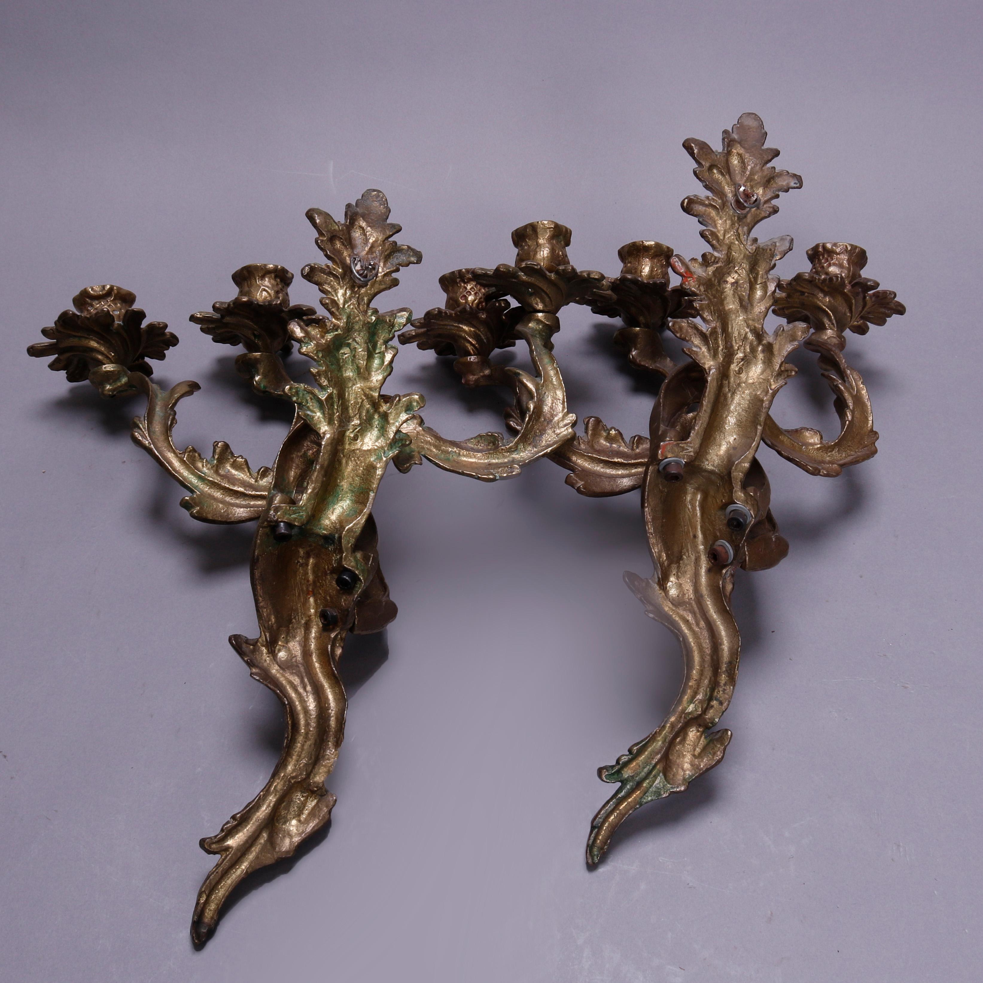 An antique pair of French Louis XIV wall sconces offer gilt cast metal construction in foliate form having three arms terminating in candle sockets, circa 1880. 

Measures: 15