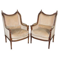 Paire de bergères françaises anciennes de style Louis XVI, structure en noyer sculpté, rembourrées de duvet