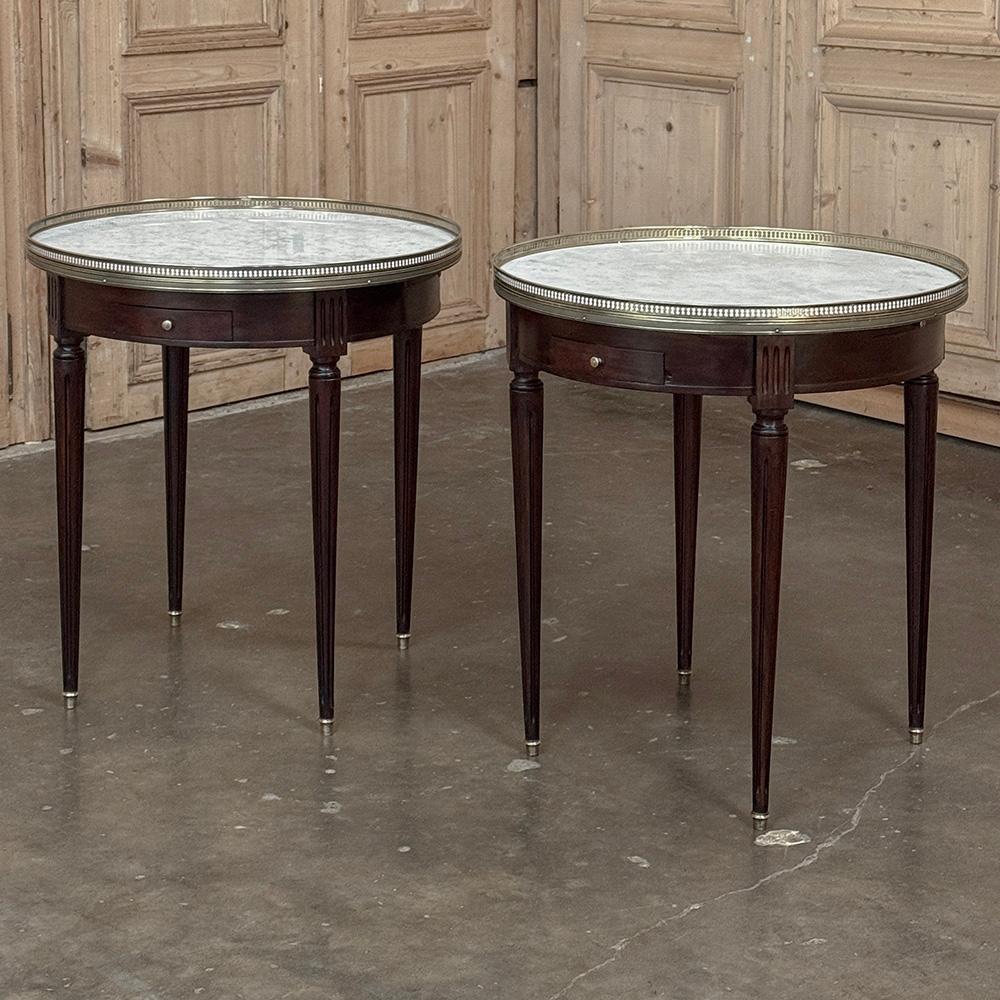 COPPIA di Tavoli Bouillotte con piano in marmo di Antique French Louis XVI rappresenta un'eleganza sobria, perfetta per un arredamento sartoriale ma raffinato. Realizzato a mano in mogano esotico importato, presenta un grembiule rotondo interrotto