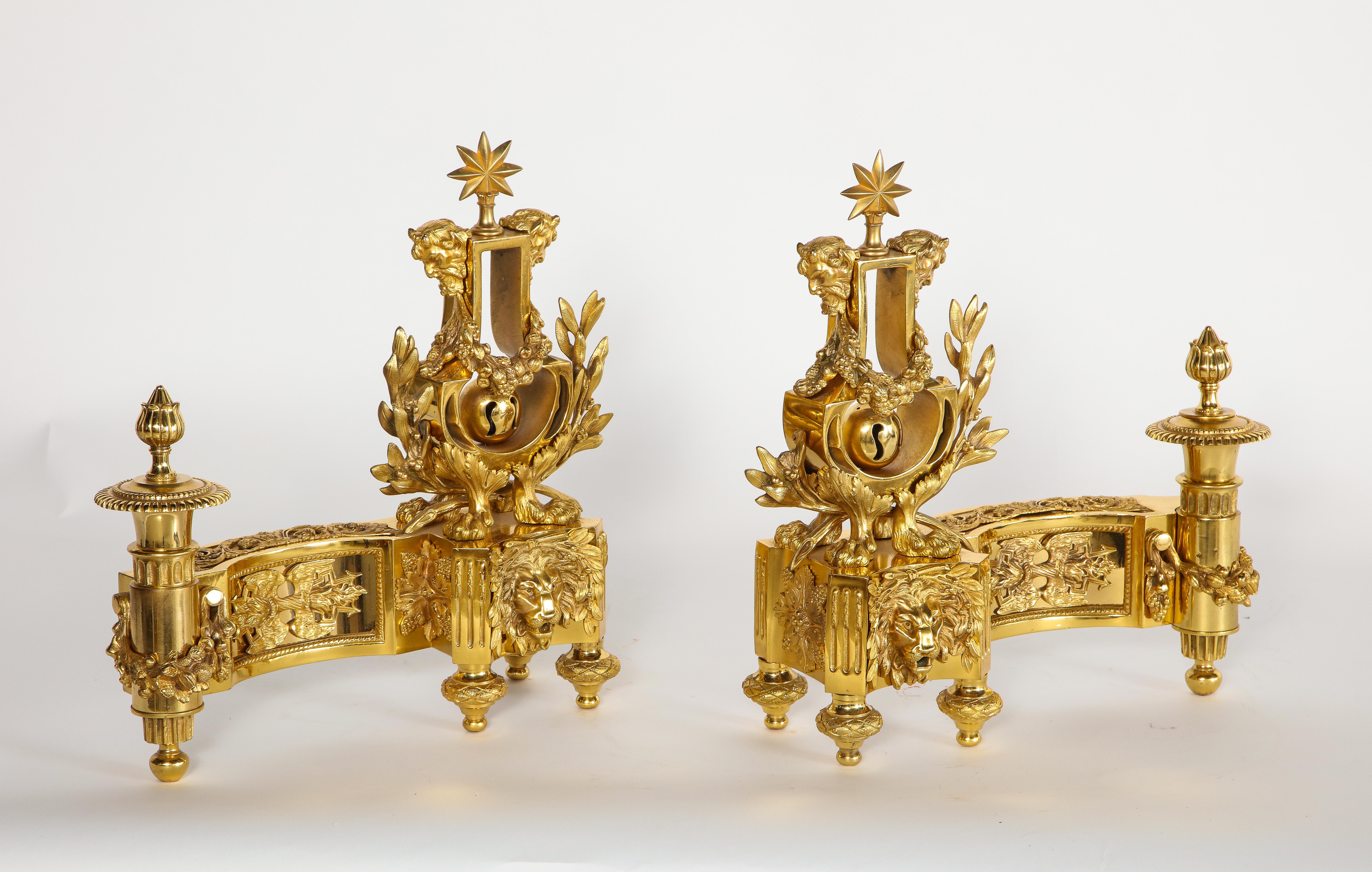 A fabulous pair of antique Louis XVI style French dore bronze lyre form Andirons/Chennets. Each is exceptionally cast, hand-chased, and chiseled with great precision and quality. The bases are decorated with multiple high relief dore bronze panels