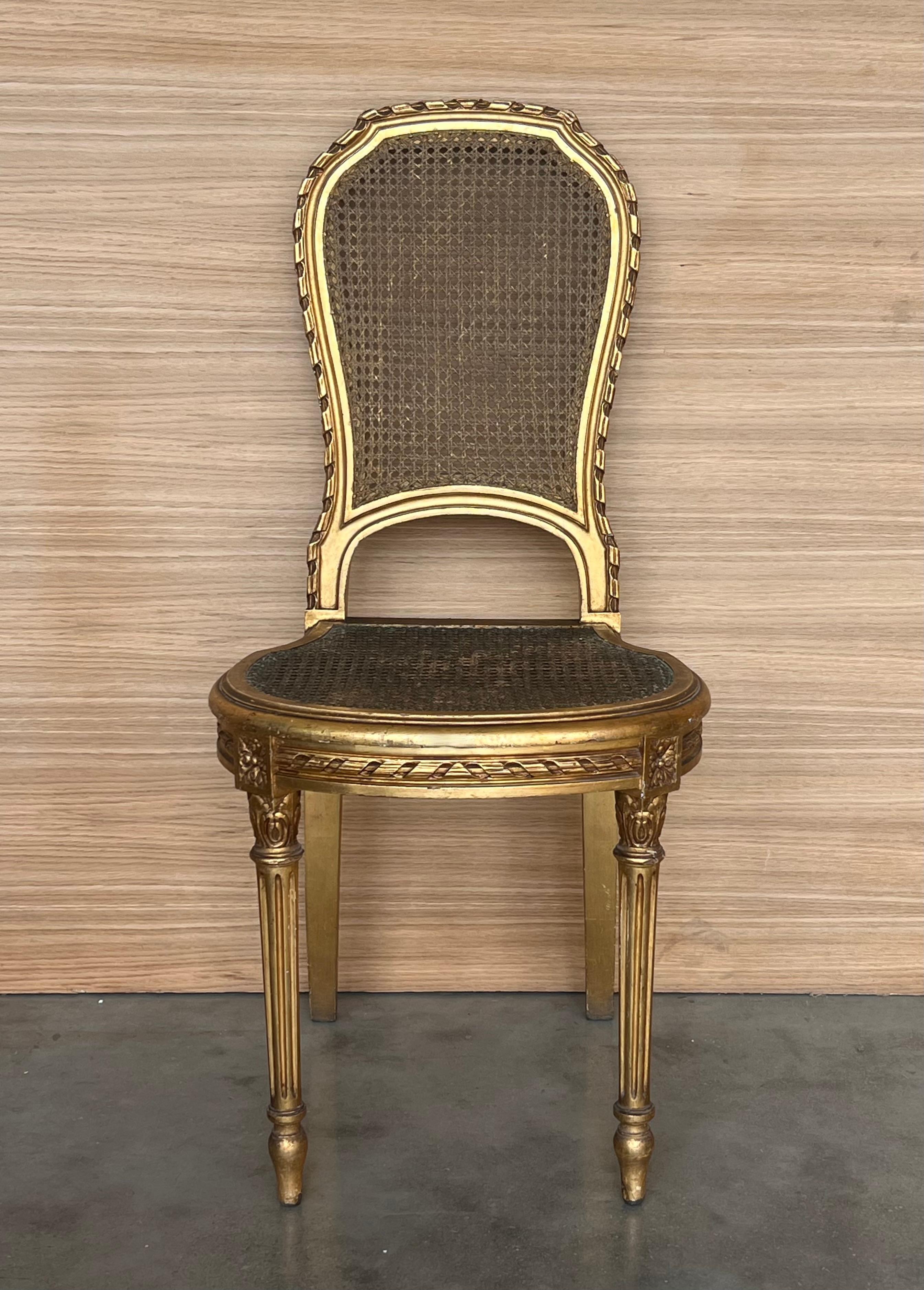Pair French Louis XVI style dining side chairs from Paris decorated with timeless classical styling and hand carved excellence on the entire framework, emphasizing typical neoclassical gilt carvings of acanthus leaves and laurel wreaths, circa