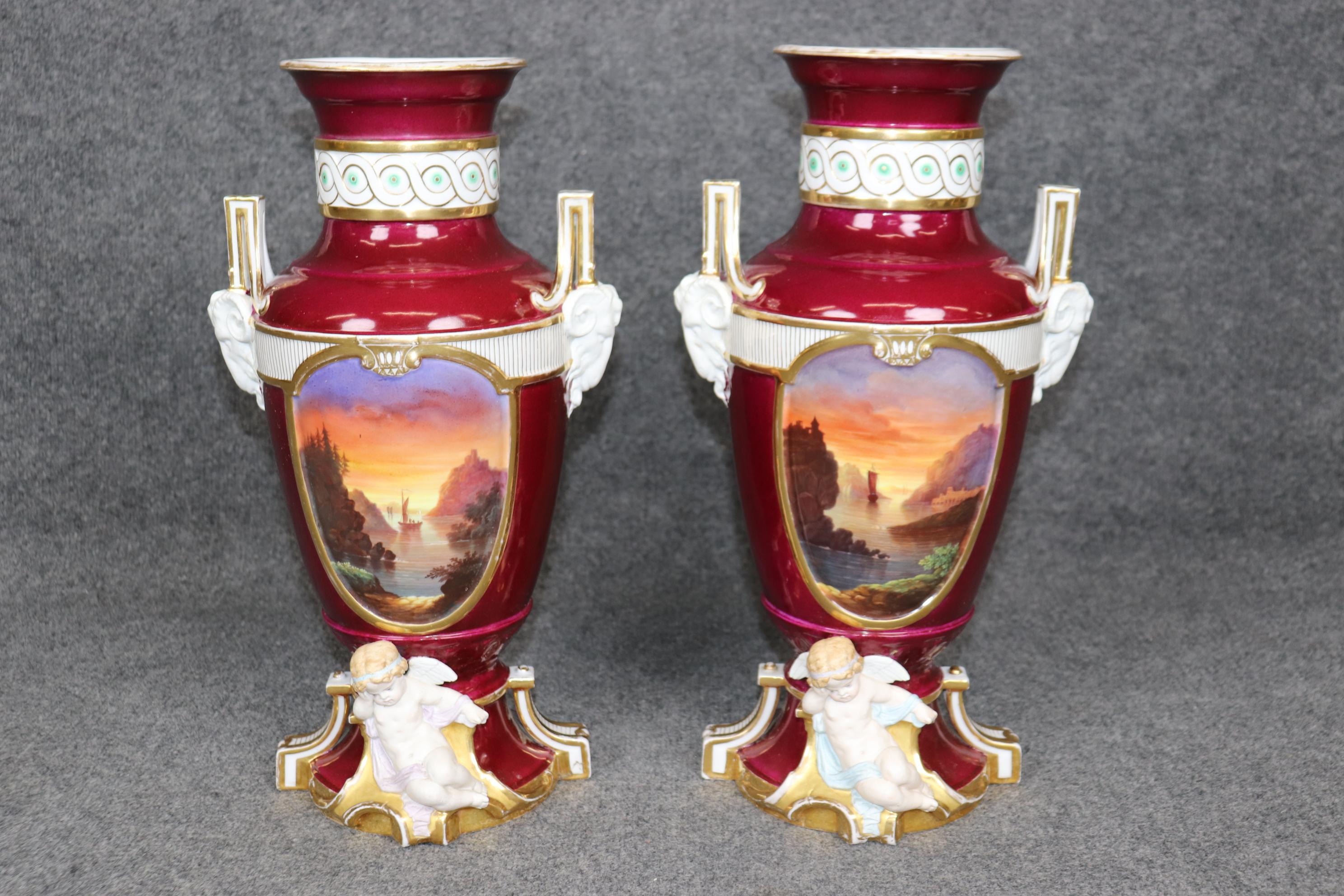 Dimensions - H: 18 1/4 in W: 10 in D: 9 in 

This stunning pair of early 20th-century porcelain vases, attributed to the prestigious Old Paris manufactory, combines neoclassical elegance with romantic naturalism, making them a perfect example of
