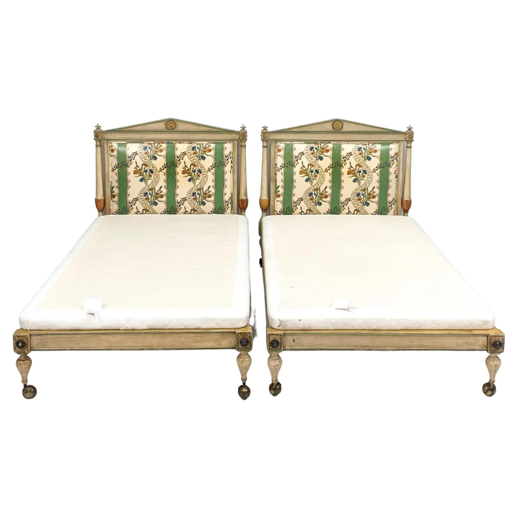 Pair of Louis XVI style antique French carved and painted twin bed frames on casters. Headboard is upholstered on front and back in different patterns. 

Note measurements: 
Dimensions: H 39