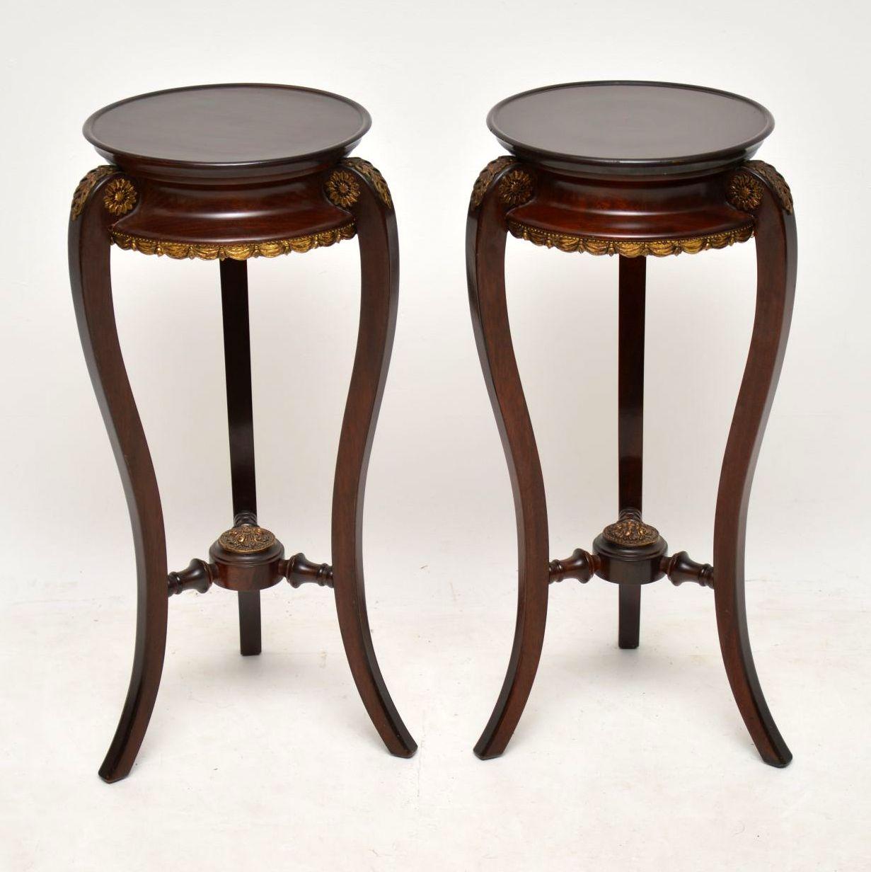 Pair of antique French style mahogany side tables with gilt bronze mounts, dating to around the 1930s-1950s. They are in good original condition and well constructed with the cross stretchers between the legs.

Measures: Width 13 inches, 34