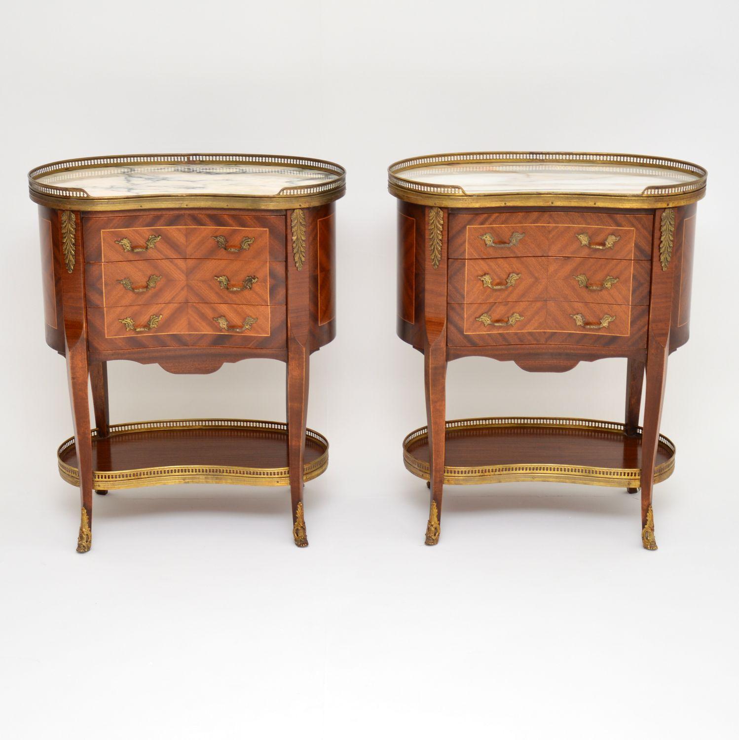 Pair of antique French style marble-top kidney shaped side tables with three drawers in each. They have pierced gilt metal galleries with swags around the marble tops and lower tiers. They also have gilt bronze mounts, feet and handles. The wood is