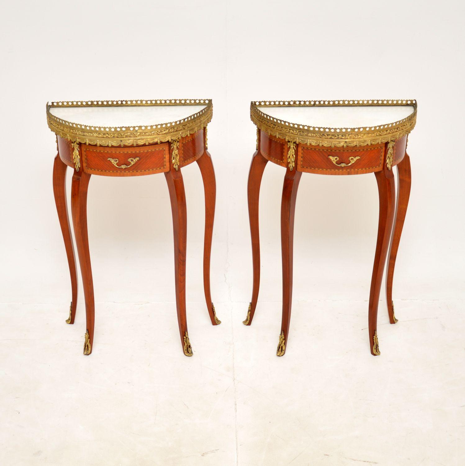 A stunning pair of antique French Demilune side tables, dating from around the 1950s.

They are a very useful Size and are of superb quality. They have white marble tops, high quality gilt metal mounts and a beautiful pierced gallery around the