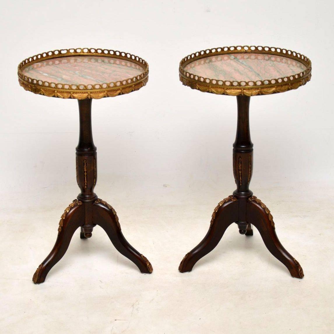Pair of antique French marble-top wine tables in good condition, having just been polished and dating from circa 1930s period. The tops are matching marble and surrounded by gilt bronze pierced galleries with swags below. They sit on turned mahogany