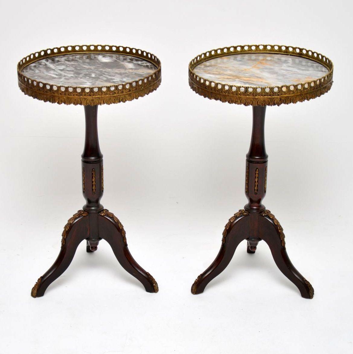 Pair of antique French style marble-top wine tables in good original condition and dating to around the 1930s-1950s period. The marble tops are surrounded by pierced gilt metal galleries and the mahogany bases have plenty more gilt mounts. They are