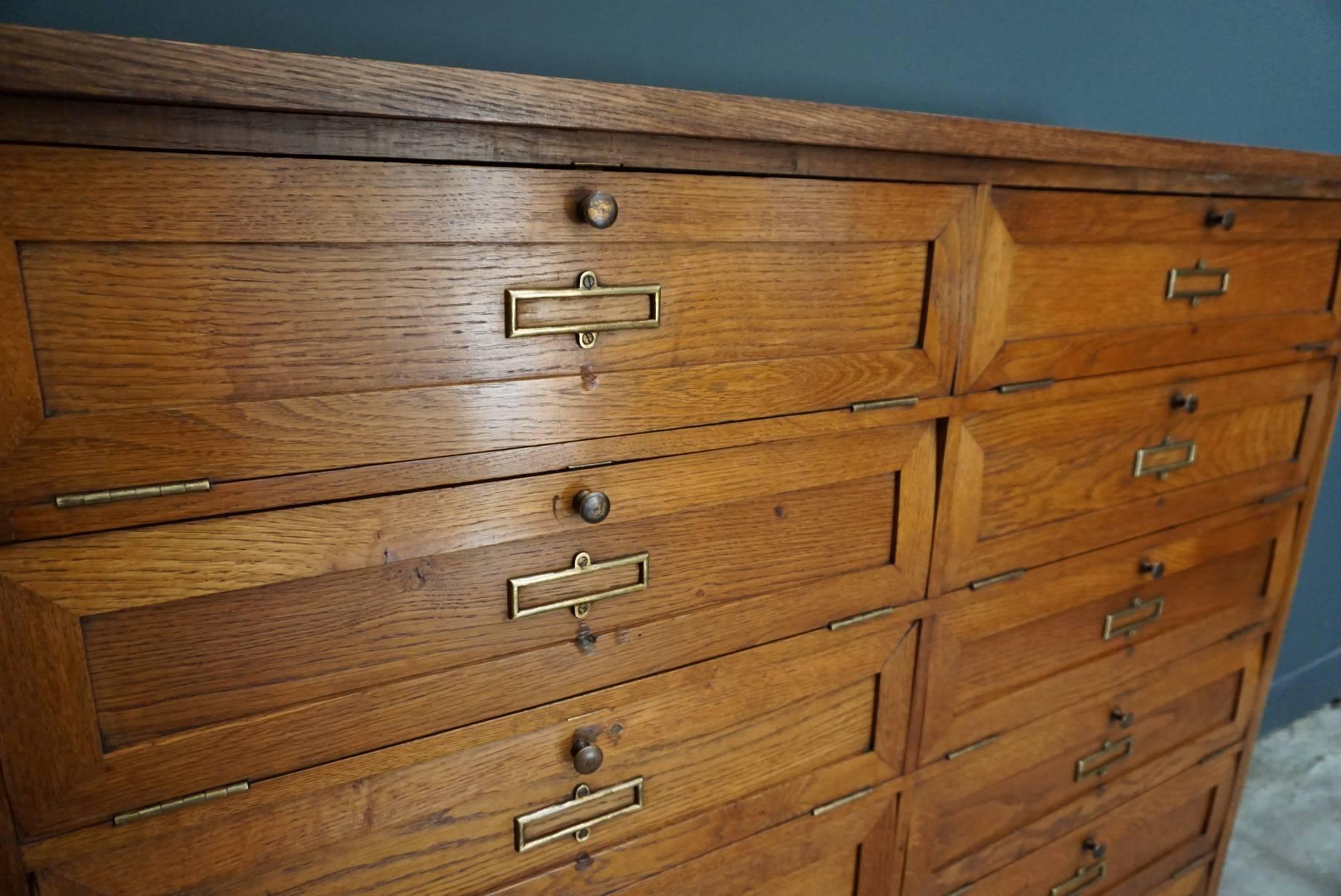 These French oak cabinets were designed and made, circa 1900 in France. They feature 14 compartments with drop down doors that were used to store files. They were previously owned and used by the bank of France. They are listed as separate items, if