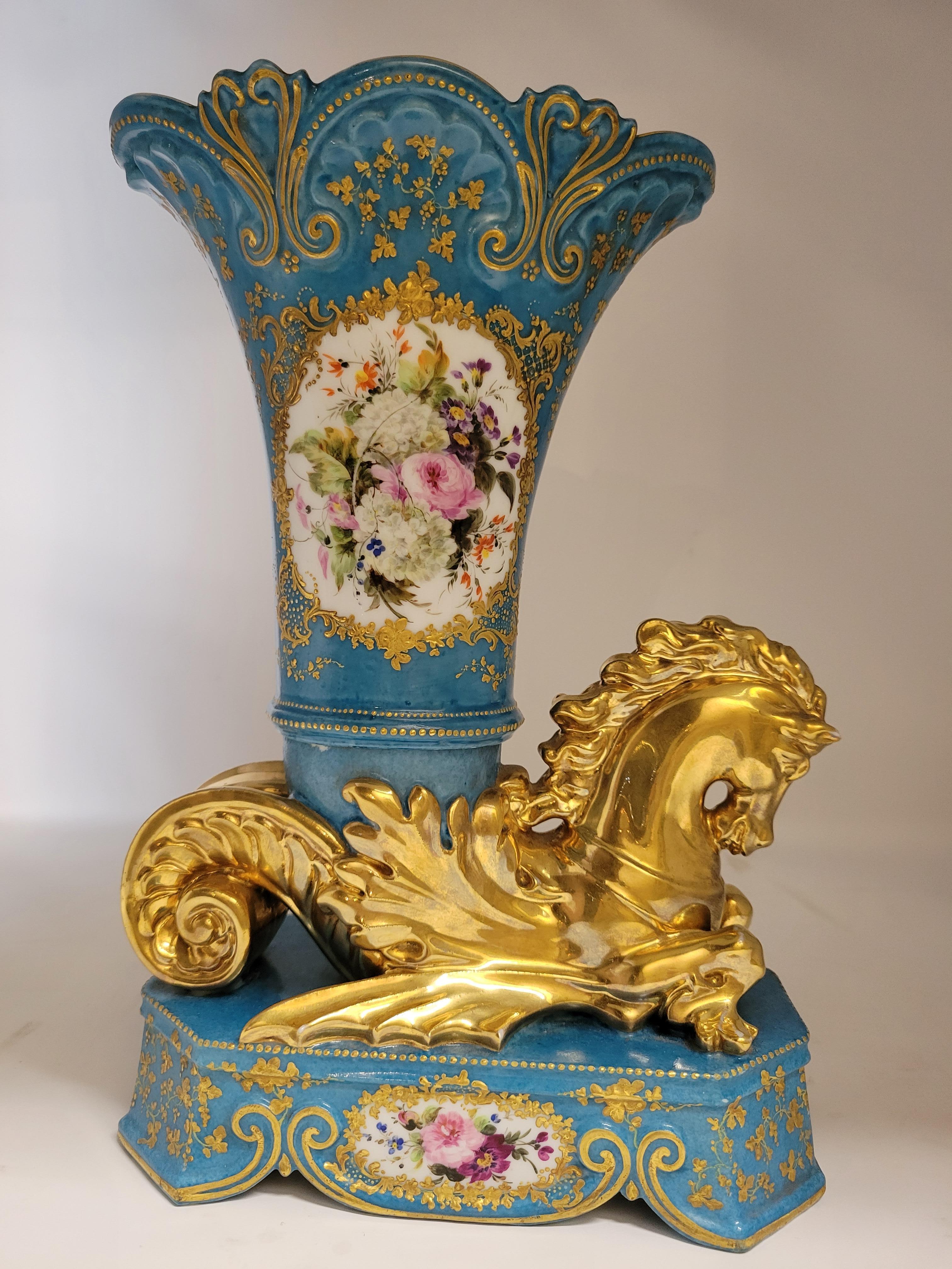 This pair of vases is appealing with its combination of colors, the nice shade of blue, the floral decorative elements and the lions above the pedestal bases.