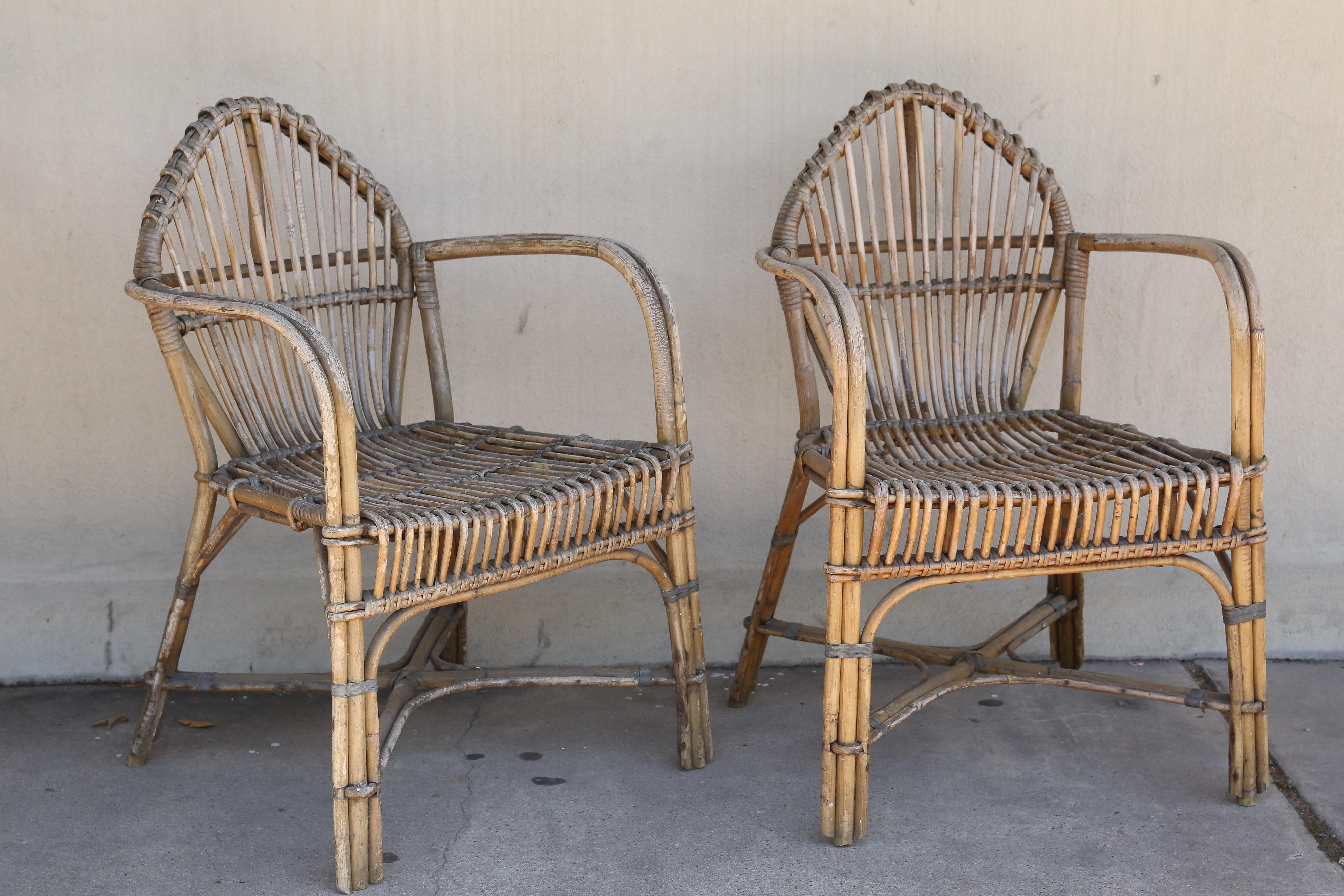 A charming pair of antique French rattan armchairs, found in Belgium, perfect for your outdoor living space or inside, bringing the natural element of hand-worked rattan to your environment. These look fantastic with oversized pillows, and have a
