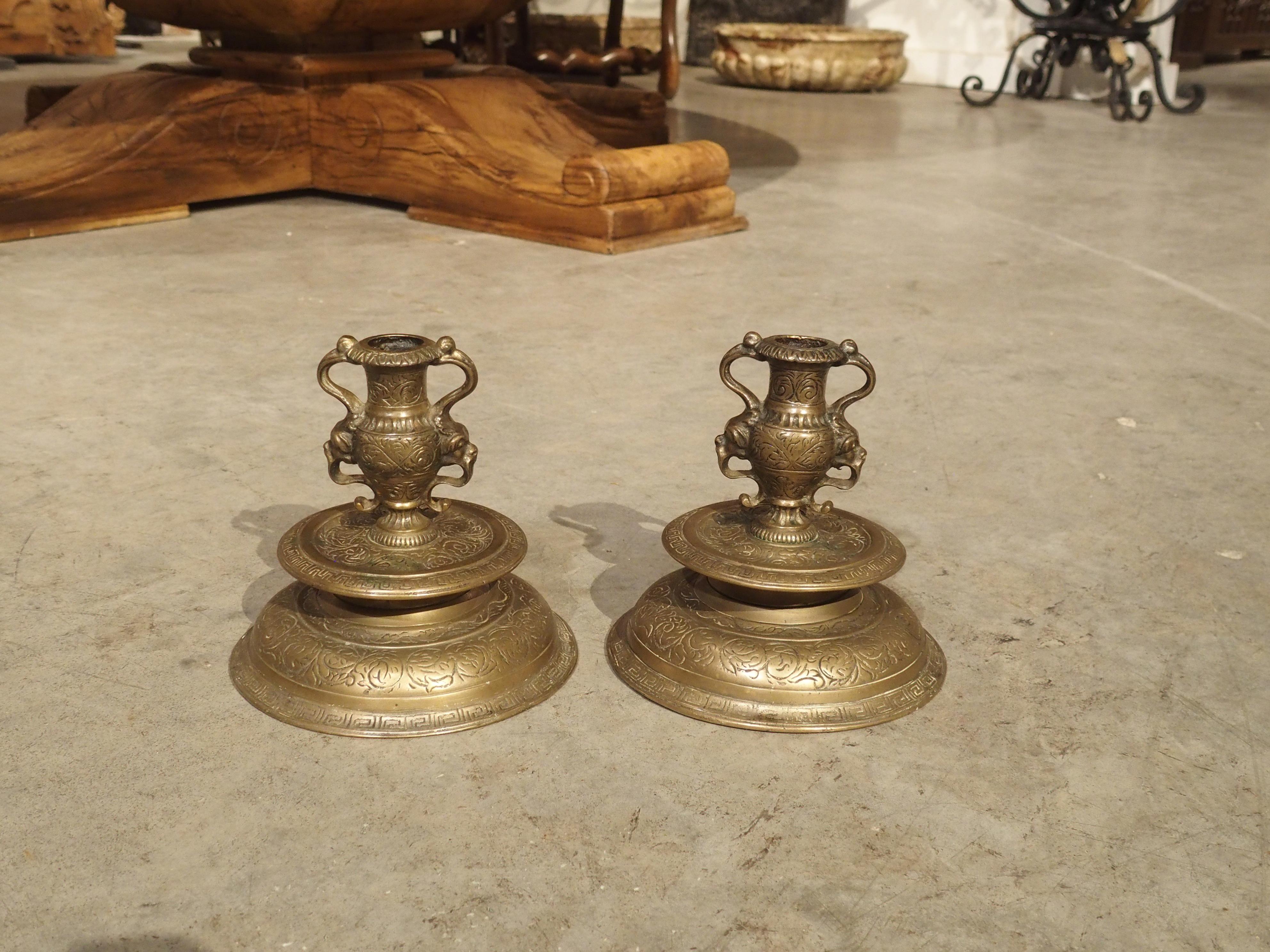 This pair of small 19th century bronze candlesticks (“bougeoirs” in French) was crafted in the Renaissance style.

The circular molded base has two rings of Greek key – one on the lower base and a second on the elevated bobeche. Greek key is a