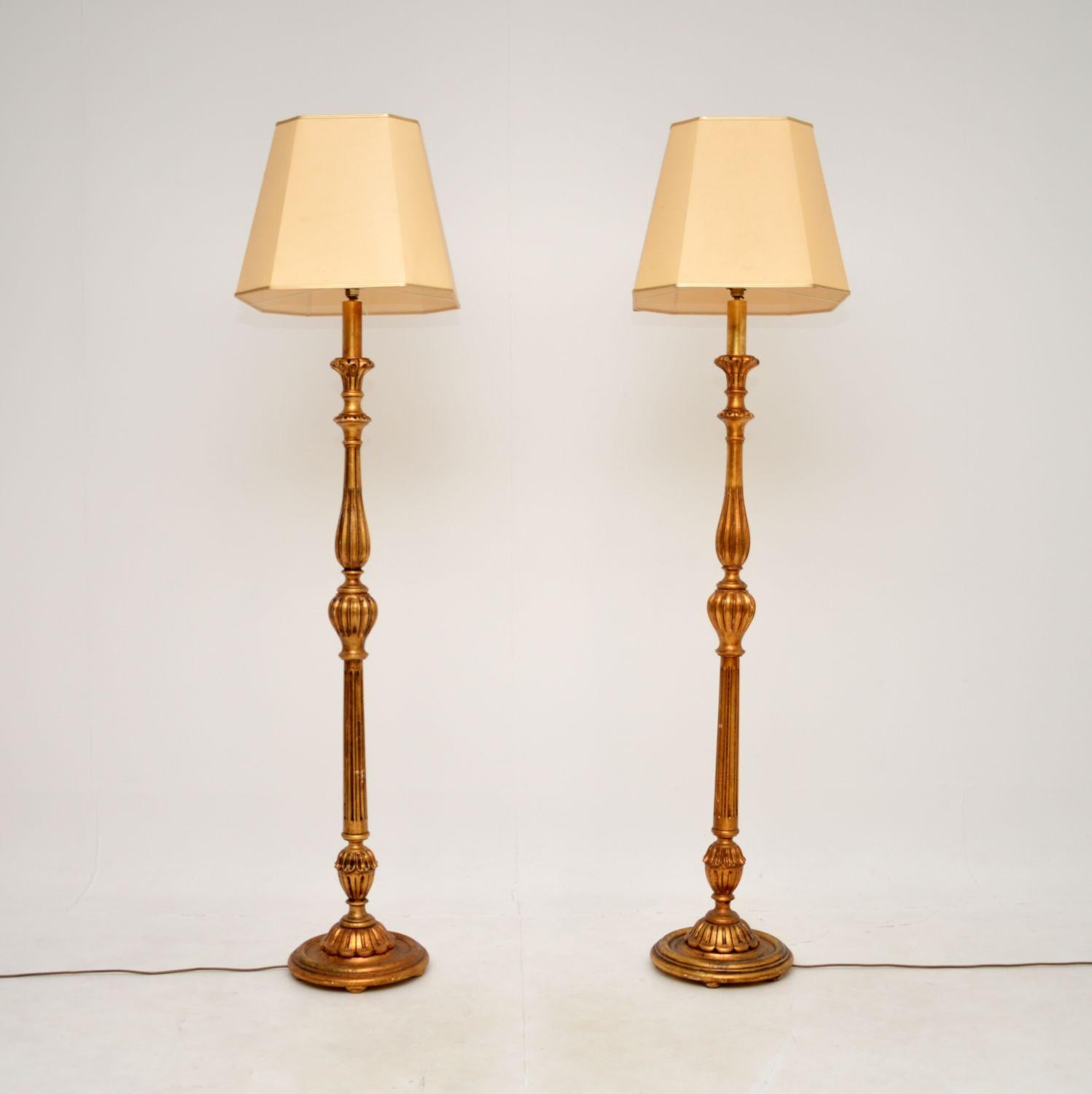 Une paire étonnante et très impressionnante d'anciens lampadaires en bois doré de style français. Fabriqués en France, ils datent des années 1950.

La qualité est superbe, ils sont magnifiquement réalisés avec des détails très fins. La finition en