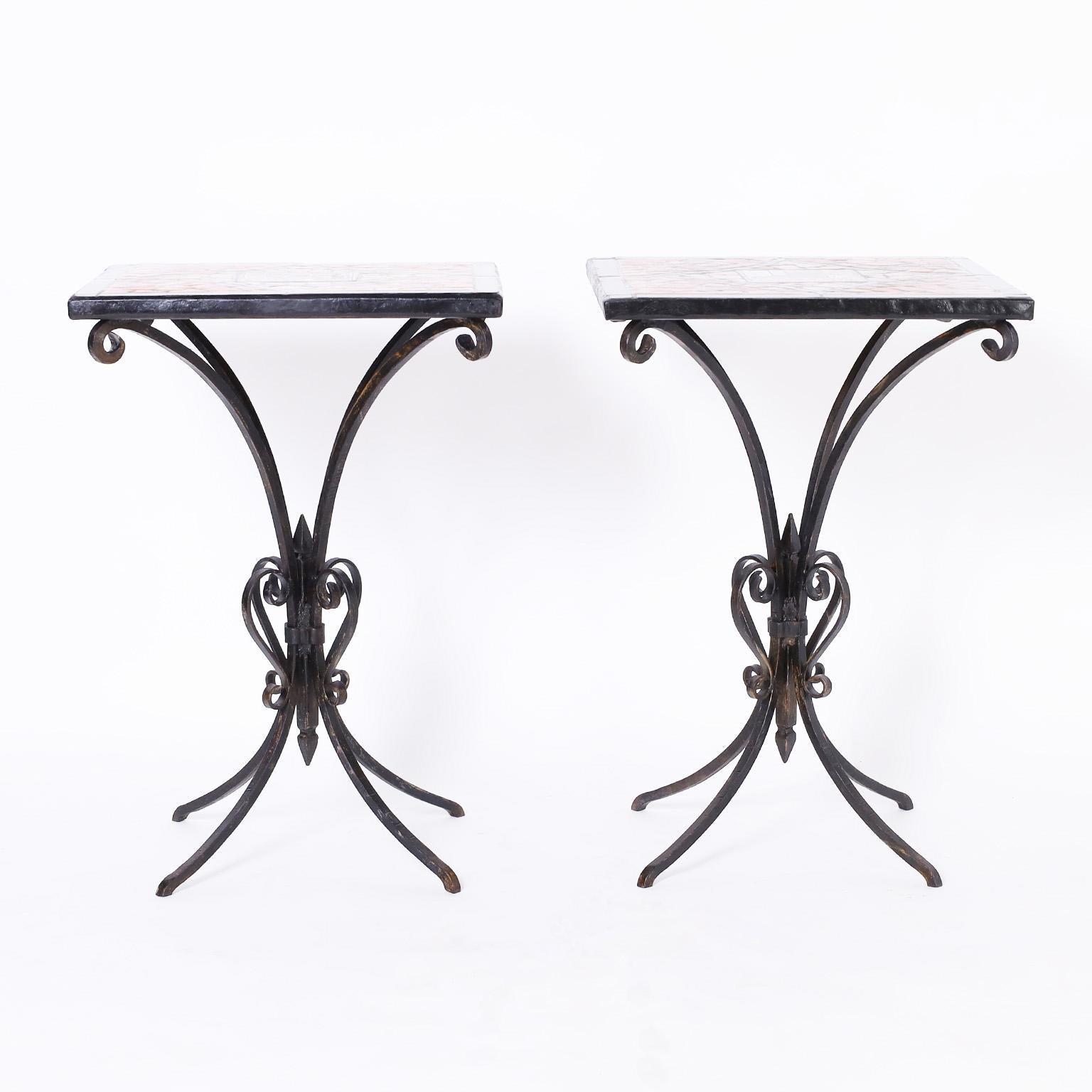 Standout pair of antique French tables or stands with colorful mosaic tiled tops having art nouveau style center tiles. The bases are hand wrought iron in an elegant form.