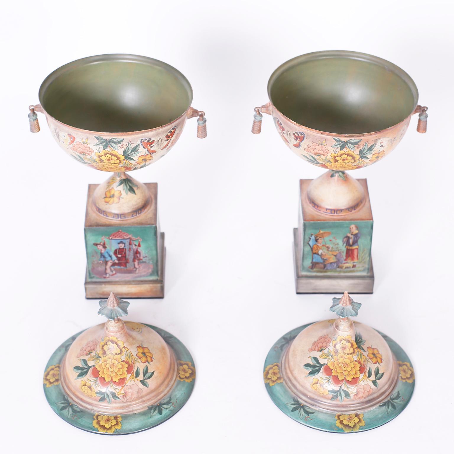 Antique pair of French tole lidded urns or garnitures with pagoda finials and Classic form, hand painted all around with flowers and scenes of chinoiserie. Signed indistinctly on the bottom.