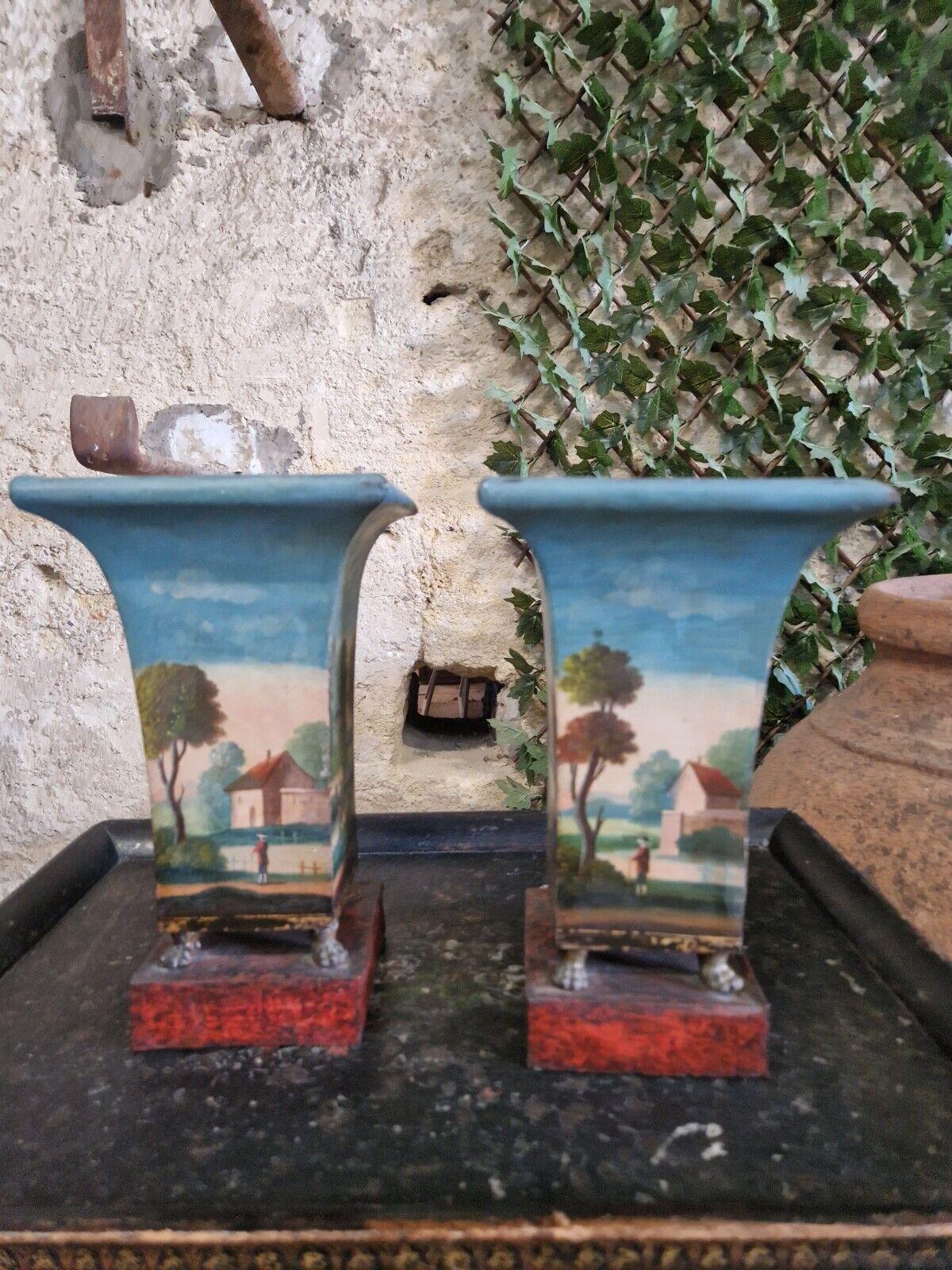 Verleihen Sie Ihrer Inneneinrichtung einen Hauch klassischer französischer Eleganz mit diesem Paar polychromer Cache-Vasen aus Metall. Diese Übertöpfe haben ein wunderschönes mehrfarbiges Landschaftsmotiv, das jeden Raum stilvoll aufwertet. Die