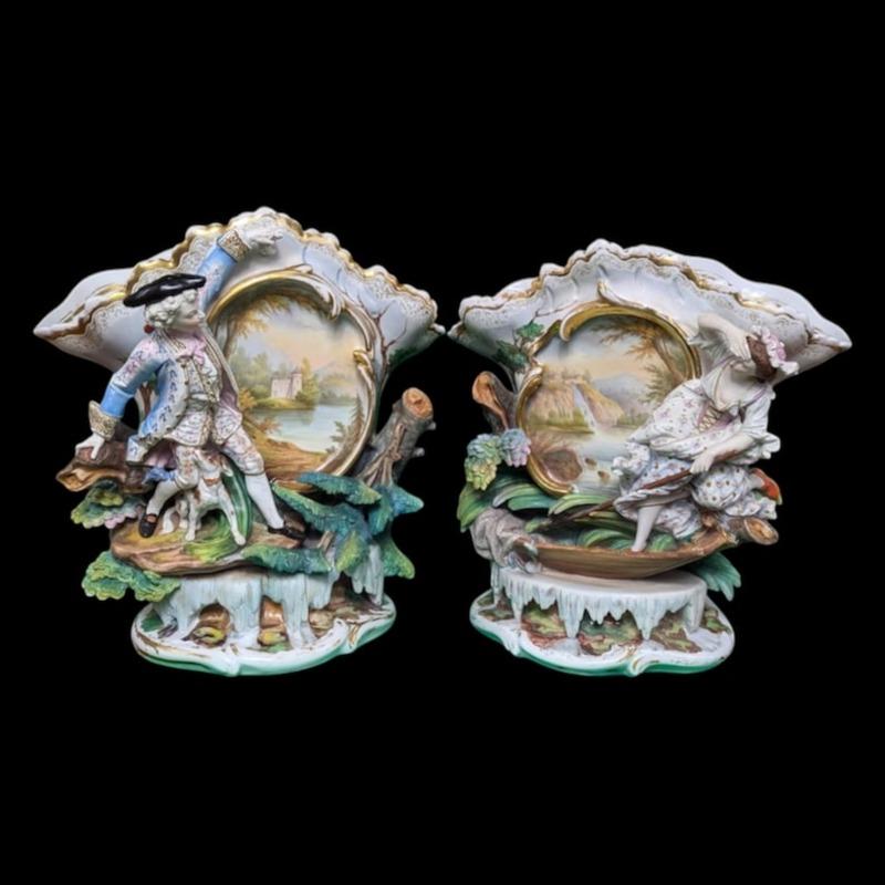 Adéntrate en un mundo de elegancia y encanto con este impresionante par de piezas figuradas francesas antiguas del Vieux Paris, cada una de las cuales representa bellamente escenas encantadoras de un hombre, una mujer y su fiel perro en medio de un