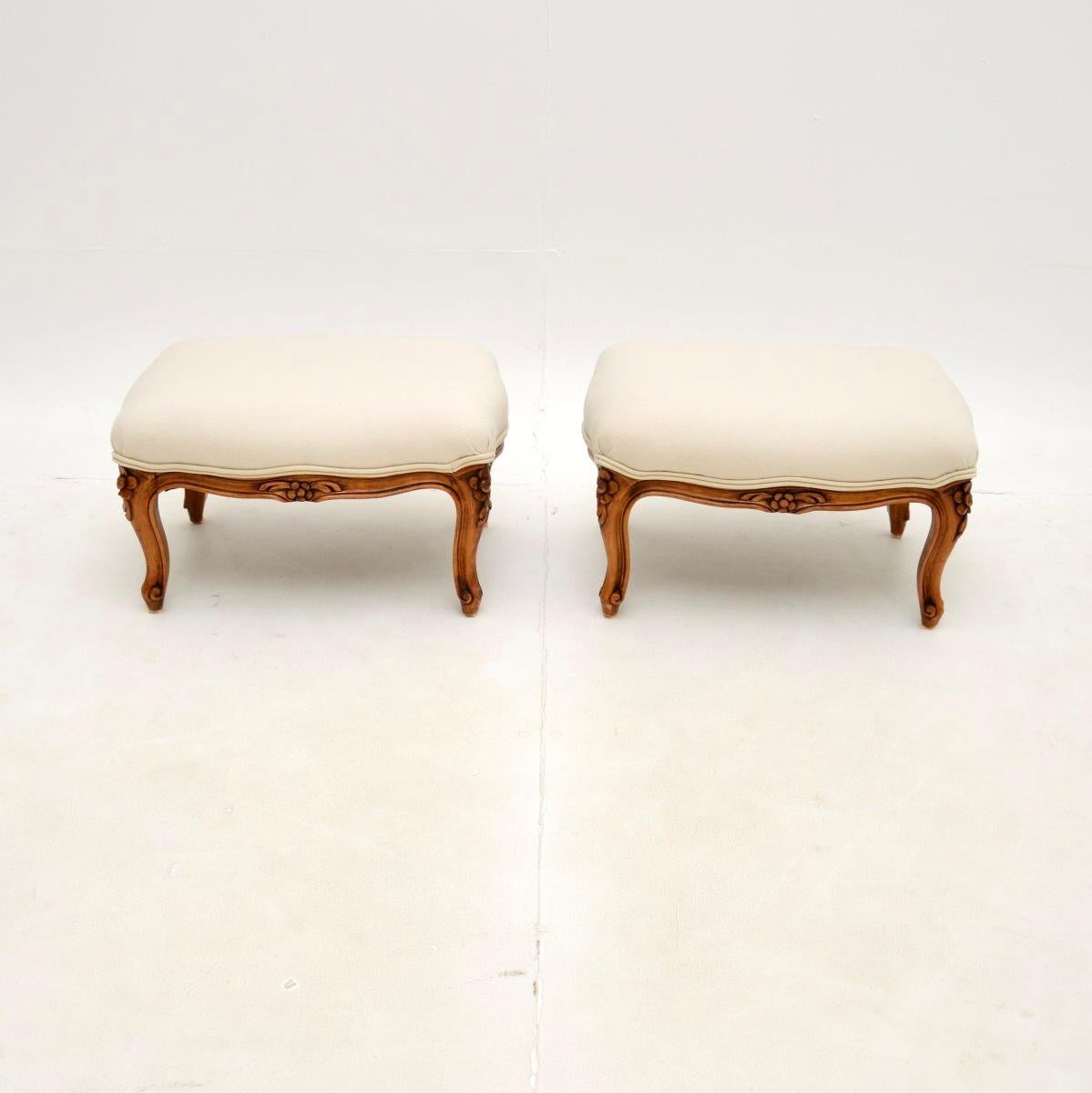 A beautiful pair of antique French walnut foot stools. They were made in France, and date from around the 1930’s.

The quality is superb, the solid walnut frames have beautiful floral carving, with cabriole shaped legs and serpentine edges.

We have