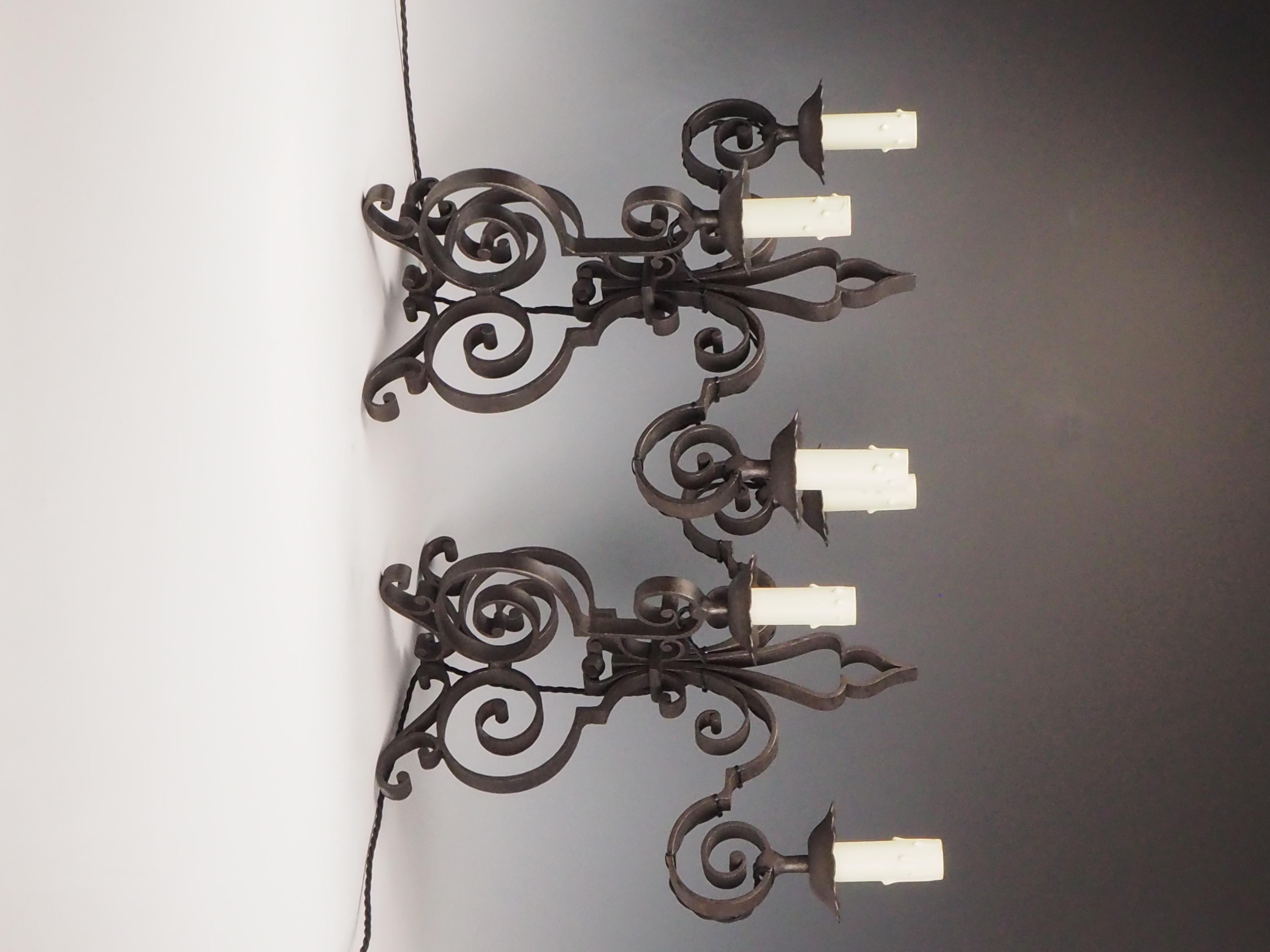 Coppia di lampade da camino o da credenza in ferro battuto francese - Design a tre luci
Una straordinaria coppia di lampade antiche francesi, realizzate in ferro battuto con dettagli ornamentali a volute e tre luci a candela. Probabilmente risalenti