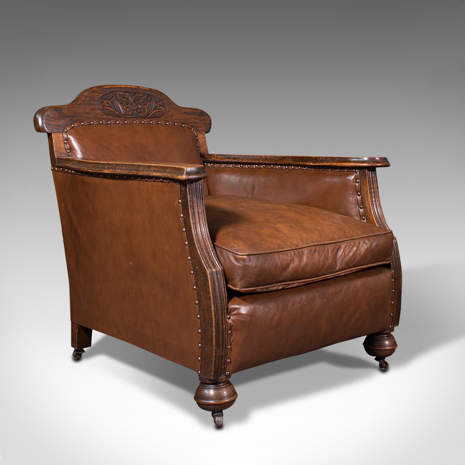 This is a pair of antique gentleman's club armchairs. An English, oak and leather fireside seat, dating to the Edwardian period, circa 1910.

Wonderfully long of thigh for relaxed use
Displays a desirable aged patina throughout
Later,
