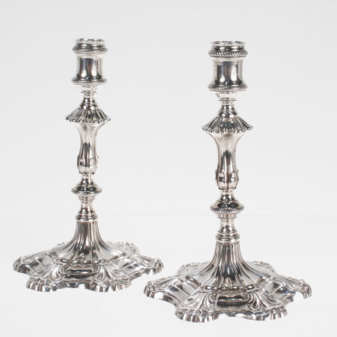 A fine pair of antique Georgian taper sticks.

In cast sterling silver.

By Ebenezer Coker of London.

Dated for 1762. 

Each with fluted hexafoil bases decorated with flower devices supporting a baluster stem and a corded candle cup.

Each lacking