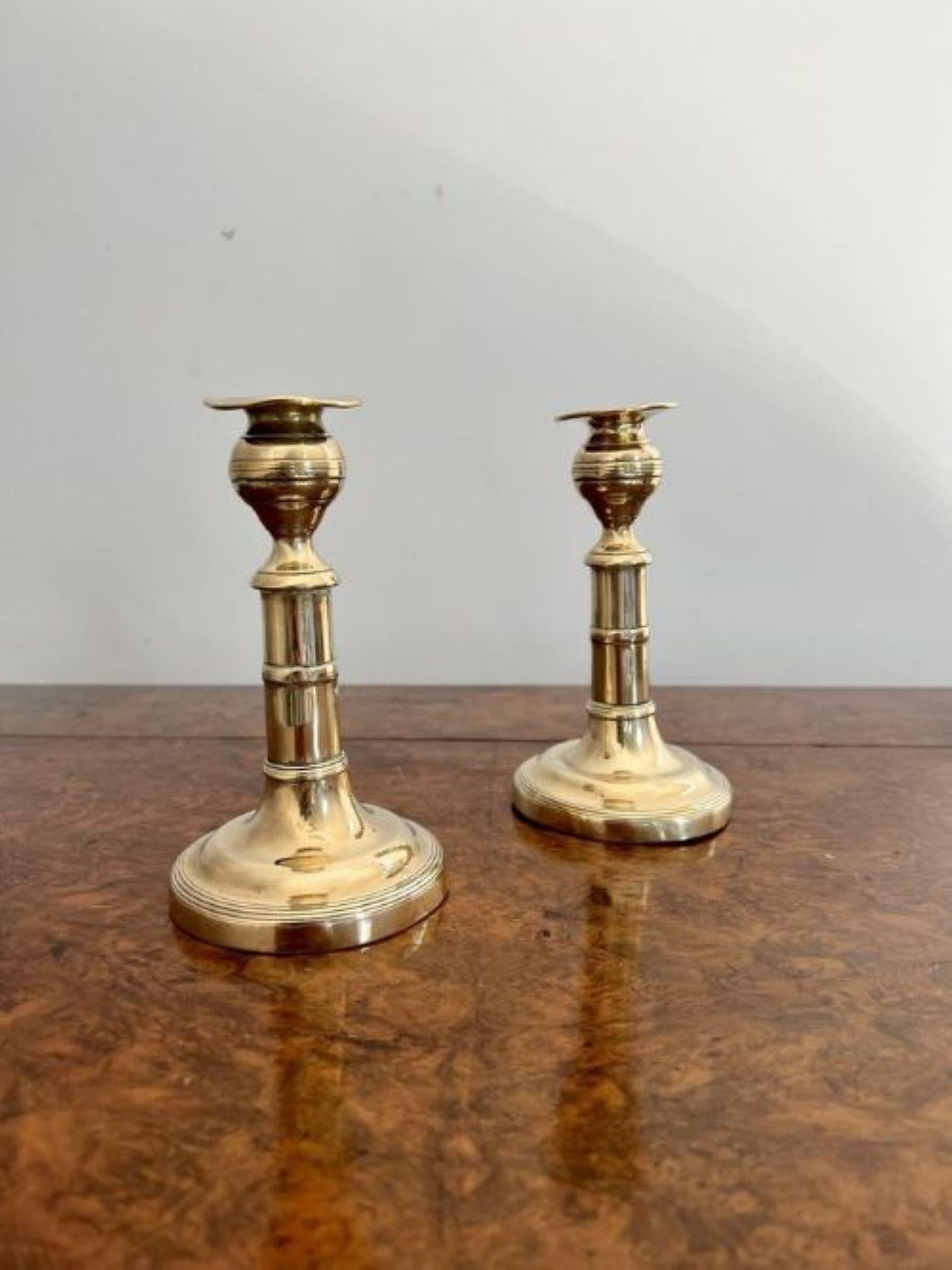 Pair of antique George III quality brass candlesticks having a turned column raised on a circular base.