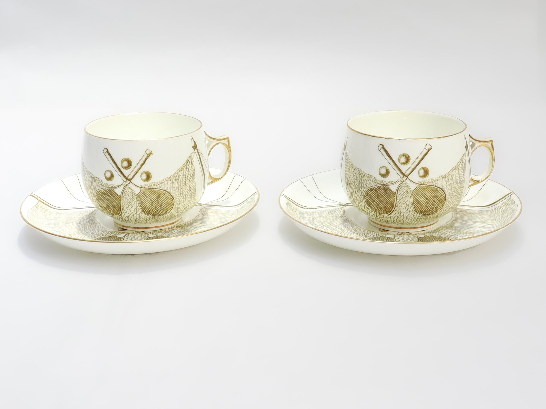 A fine pair of signed antique English porcelain cups and saucers.

By George Jones and Sons. 

In a rare tennis themed gilt patten with crossed racquets, tennis balls, and set nets.

Started in 1864 as George Jones; it became George Jones & Sons