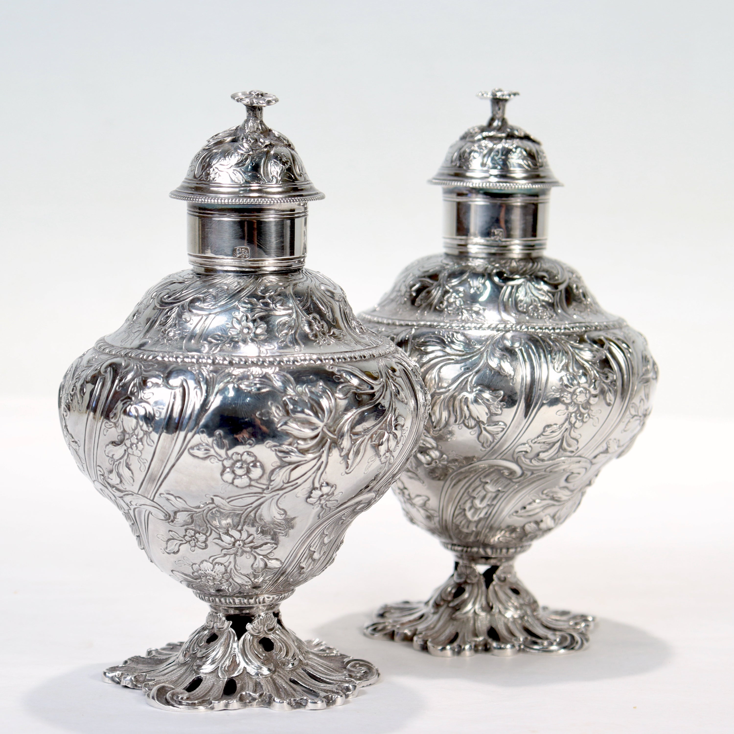 A fine matched pair of English 18th century tea caddies.

In sterling silver.

Marked for Francis Crump, London, and 1758.

Having central cartouches bearing an engraved heraldic banner with scallop shells, slightly lobed bodies with a left hand