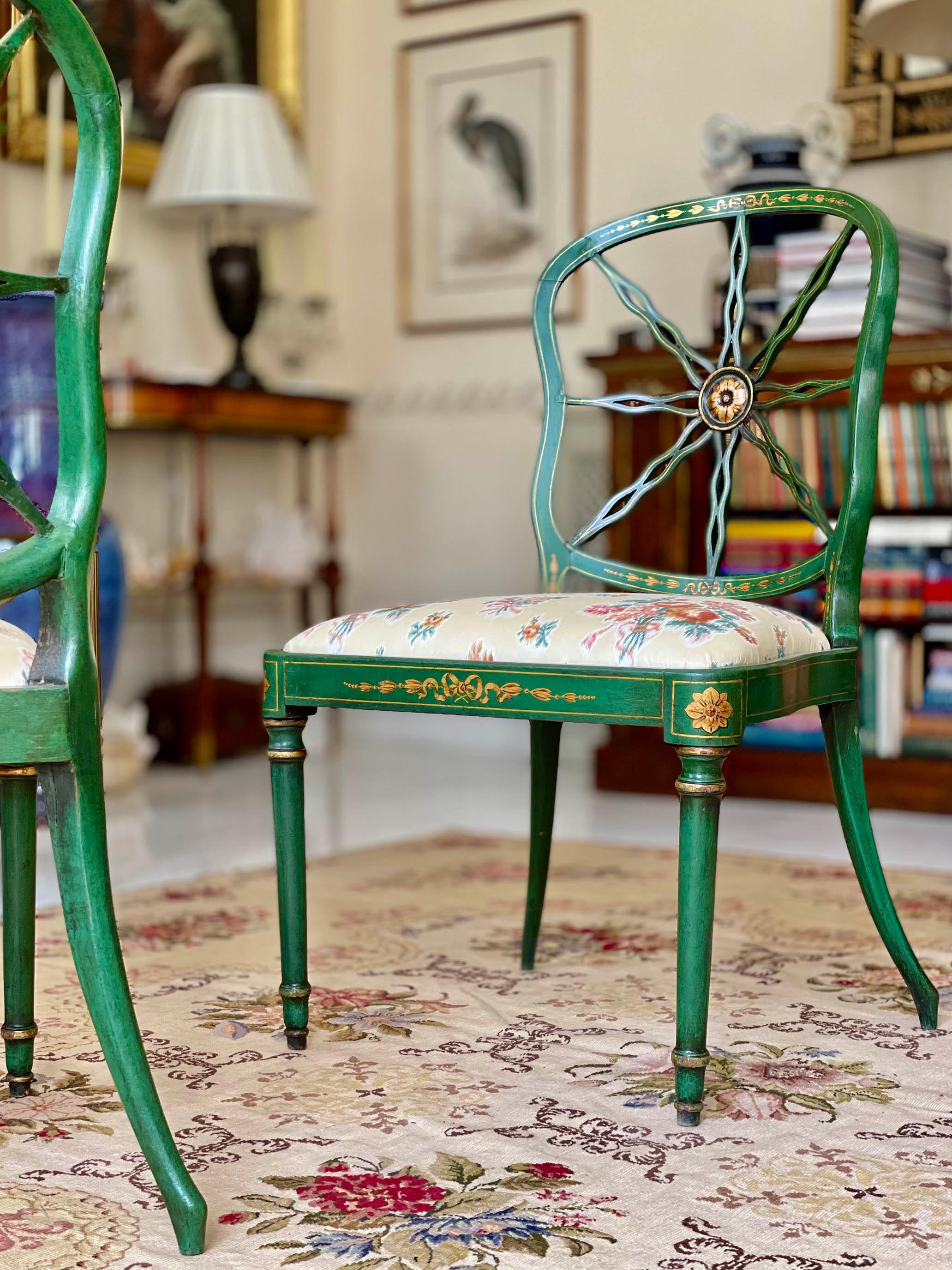 This listing is for a pair. There are three pairs available (set of six). 

A charming pair of English green painted and intricately decorated 'ribbon-back' chairs.

Why we like them
Their delicate and unusual shape, with boldly splayed back