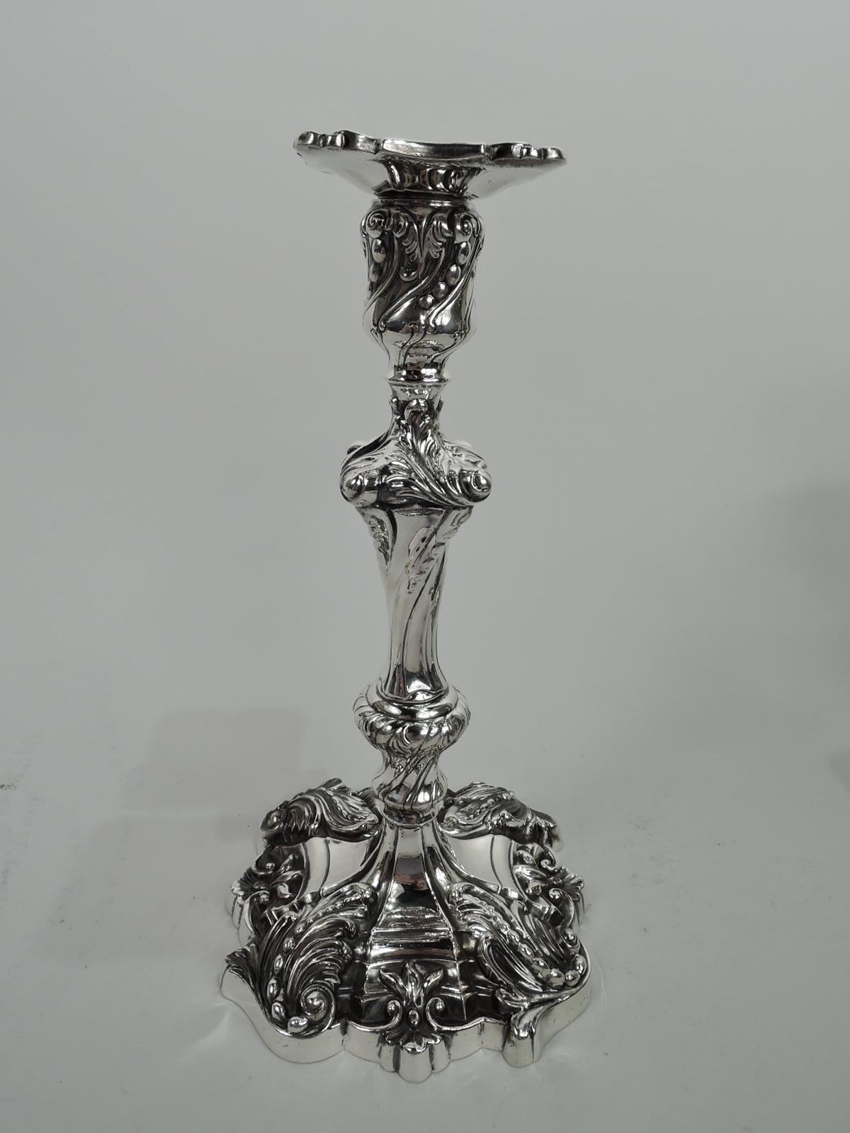 Pair of Georgian Rococo sterling silver candlesticks. Made by Dominick & Haff in New York in 1898. Each: Baluster shaft on raised and round shaped base. Concave socket with square detachable bobeche. Dense and dynamic with twisted fluting, beading,