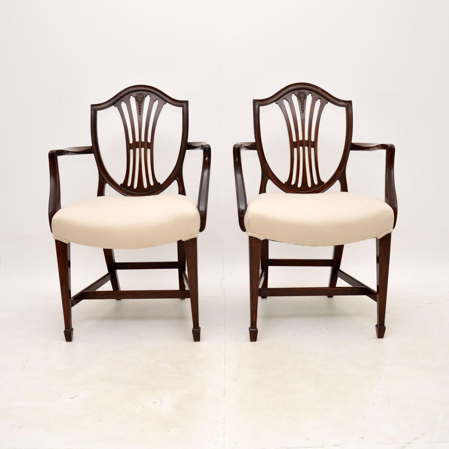 A fine pair of antique Georgian style carver armchairs. They were made in England, we would date these from around the 1900-1910 period.

They are extremely well made and beautifully designed in the Hepplewhite style. The pierced shield backs have a