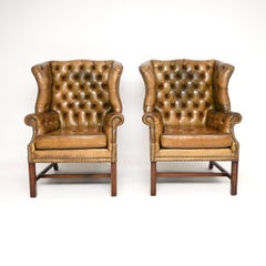 Coppia di antiche poltrone con schienale ad ala in pelle in stile georgiano